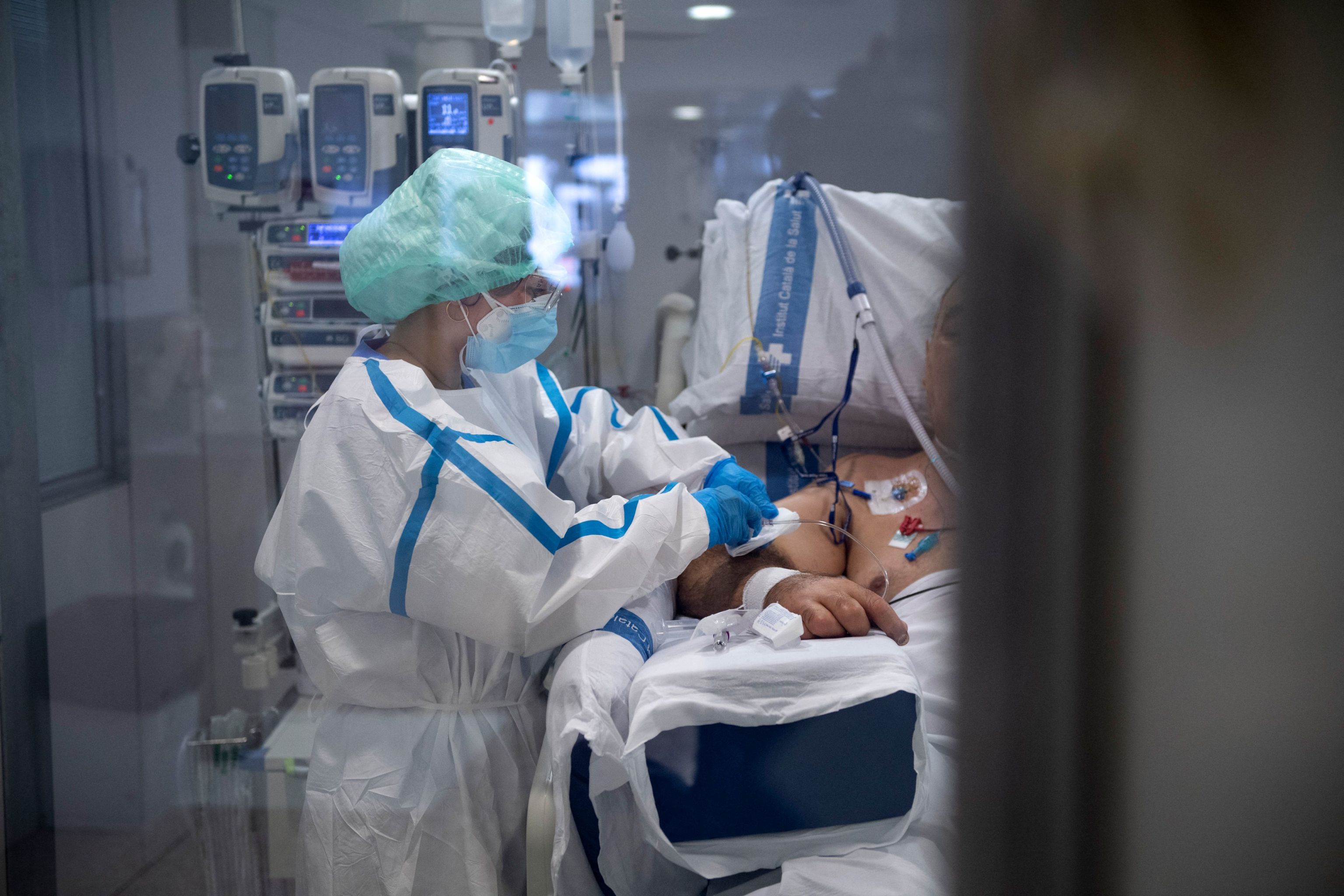 Un sanitario atiende a un paciente con Covid-19, en la UCI del Hospital Universitario de Bellvitge en Barcelona.