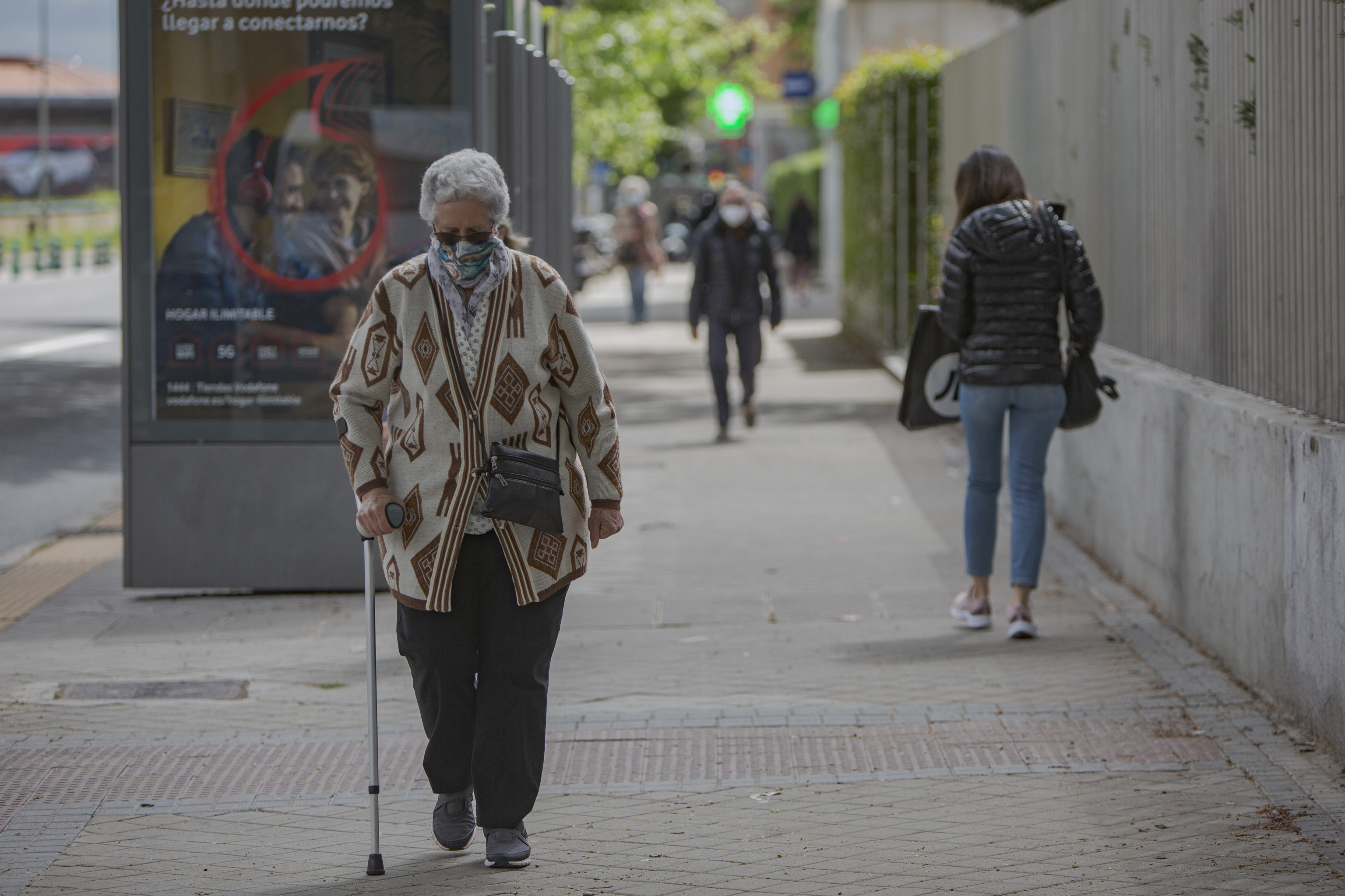 Una persona jubilada transita por la vía principal de Paseo de La Castellana de Madrid.