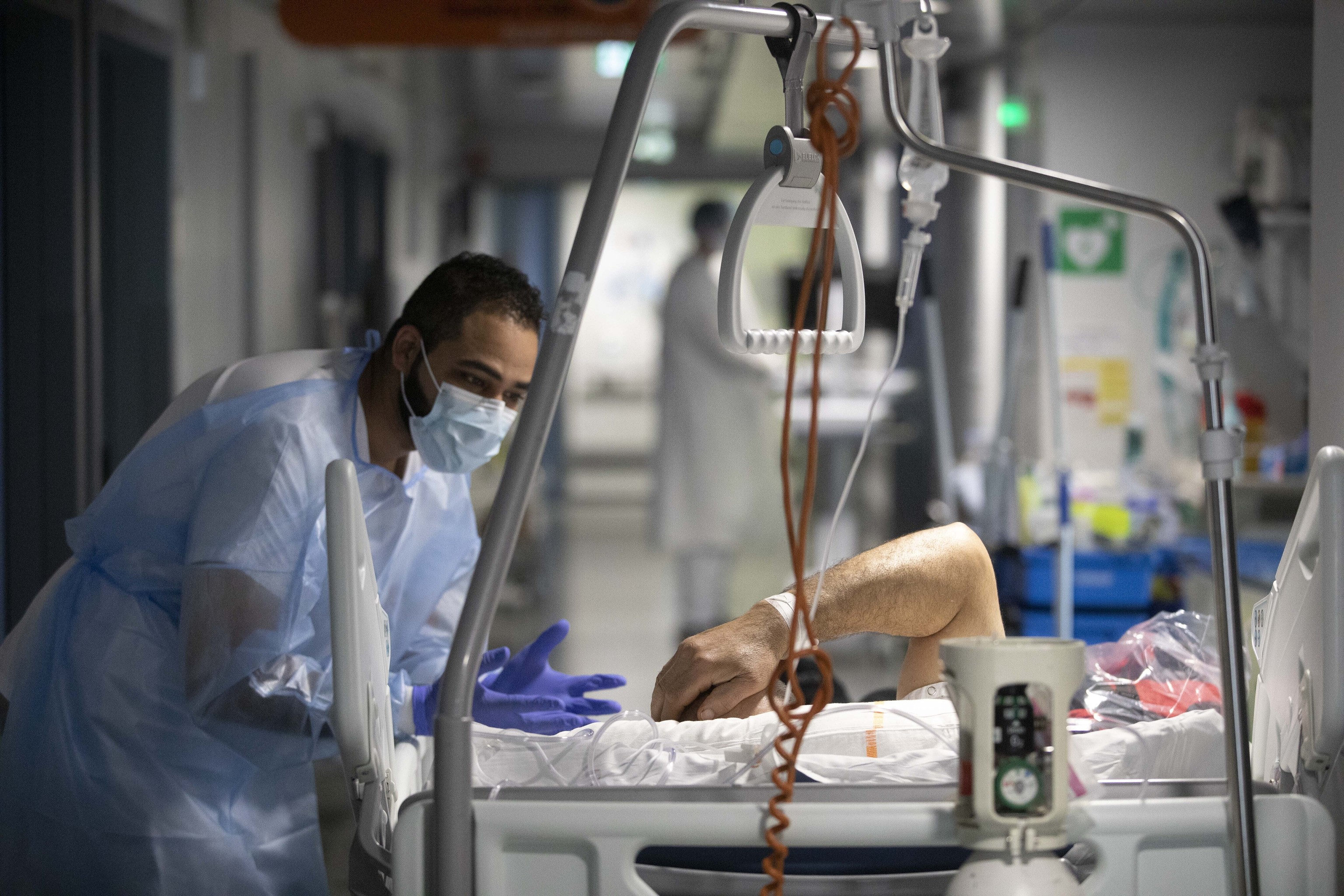 Un miembro del personal mdico habla con un paciente de COVID-19 en la sala de enfermedades infecciosas del Hospital Universitario de Estrasburgo, en el este de Francia, el jueves 13 de enero de 2022.