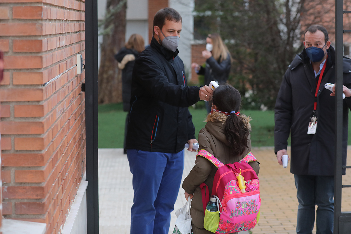 Un trabajador toma la temperatura a una alumna a su llegada al colegio en Madrid.