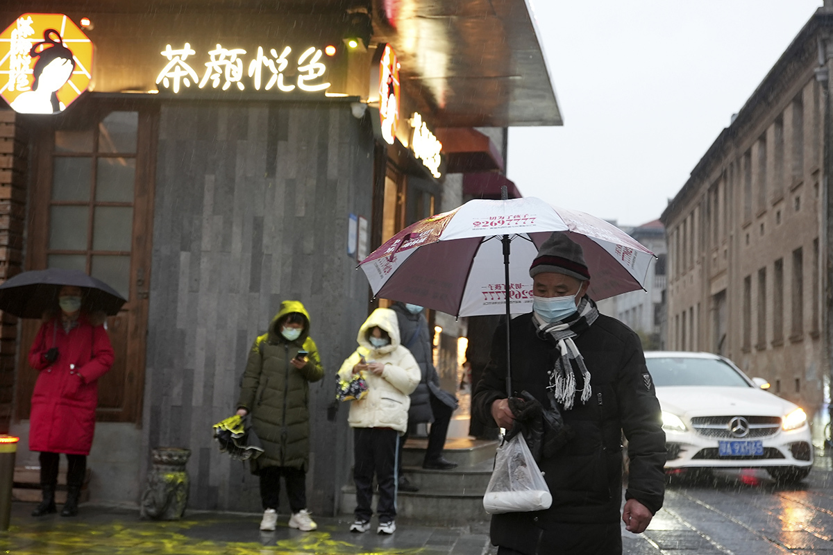Gente con mascarilla este sábado en una calle de Wuhan (China).