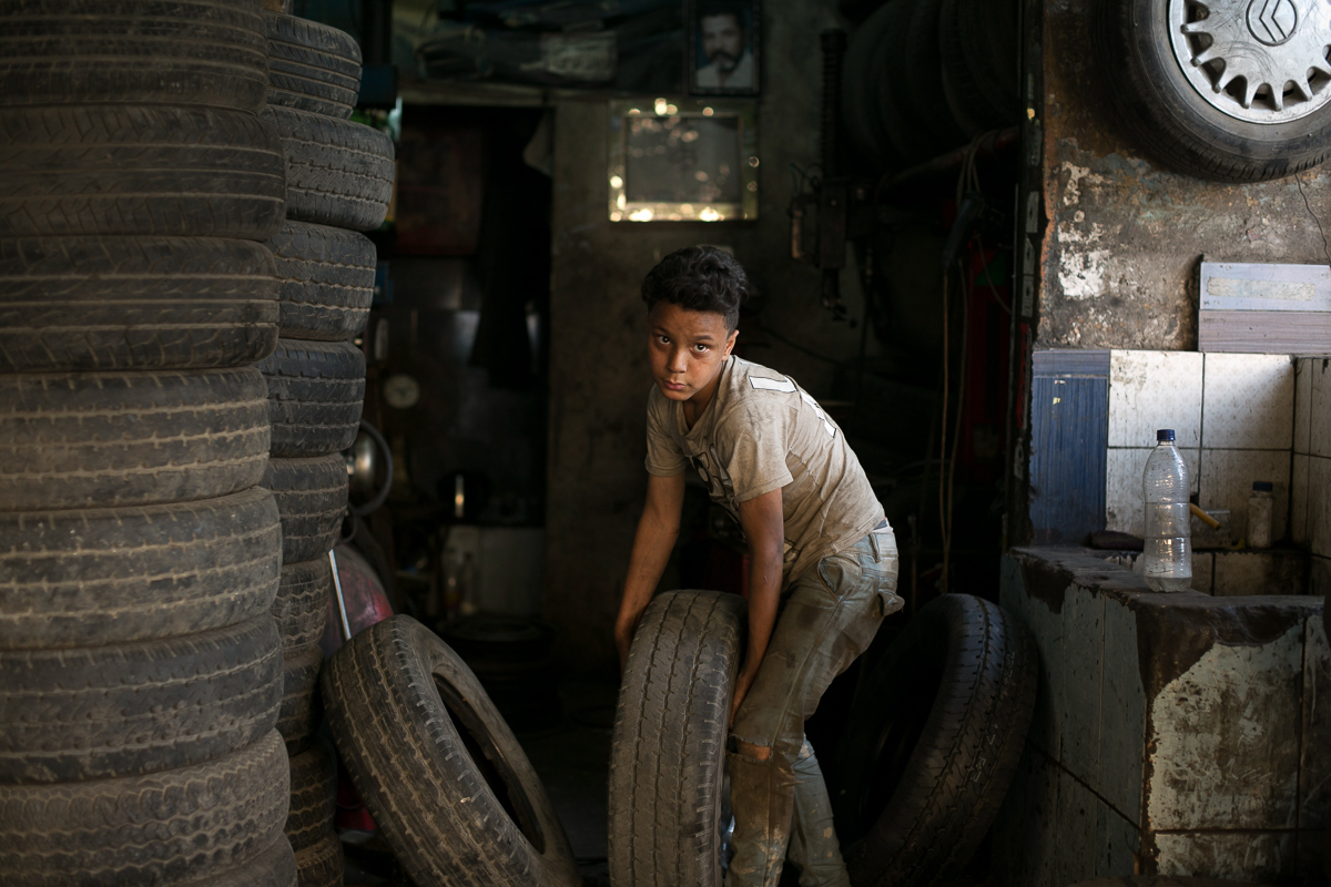 Un niño trabaja en un taller de reparación de neumáticos en El Cairo.