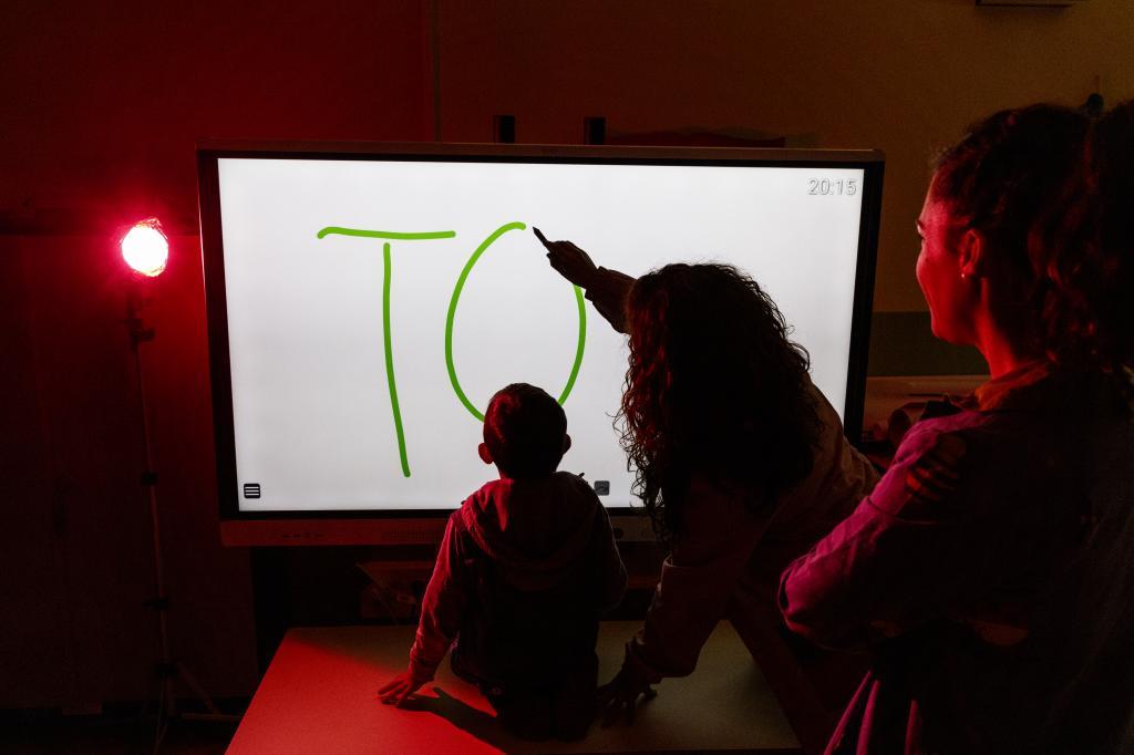 Una maestra ensea a sus alumnos mediante una pizarra digital.