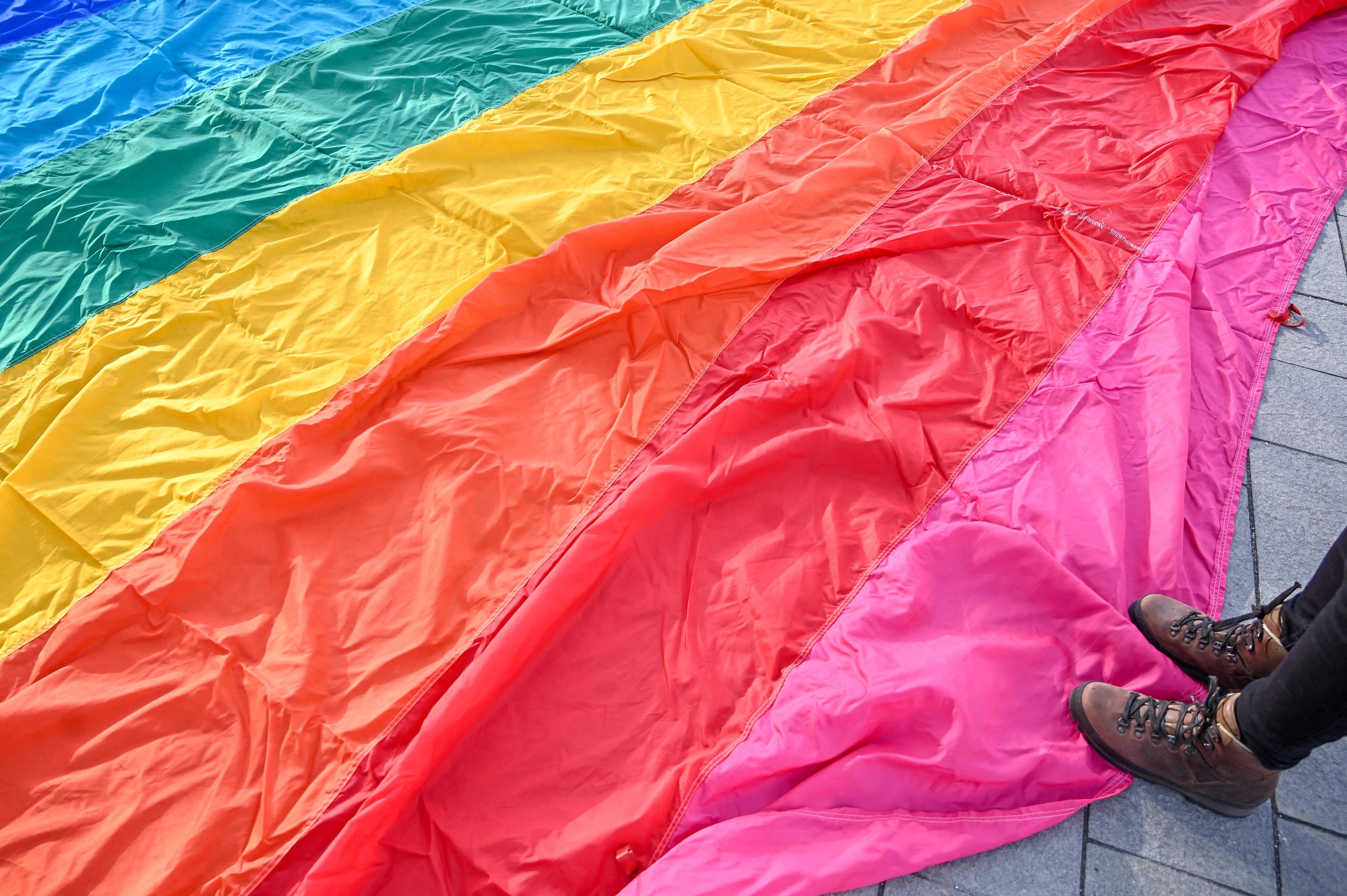 Una activista LGBT pisa una bandera arcoiris.