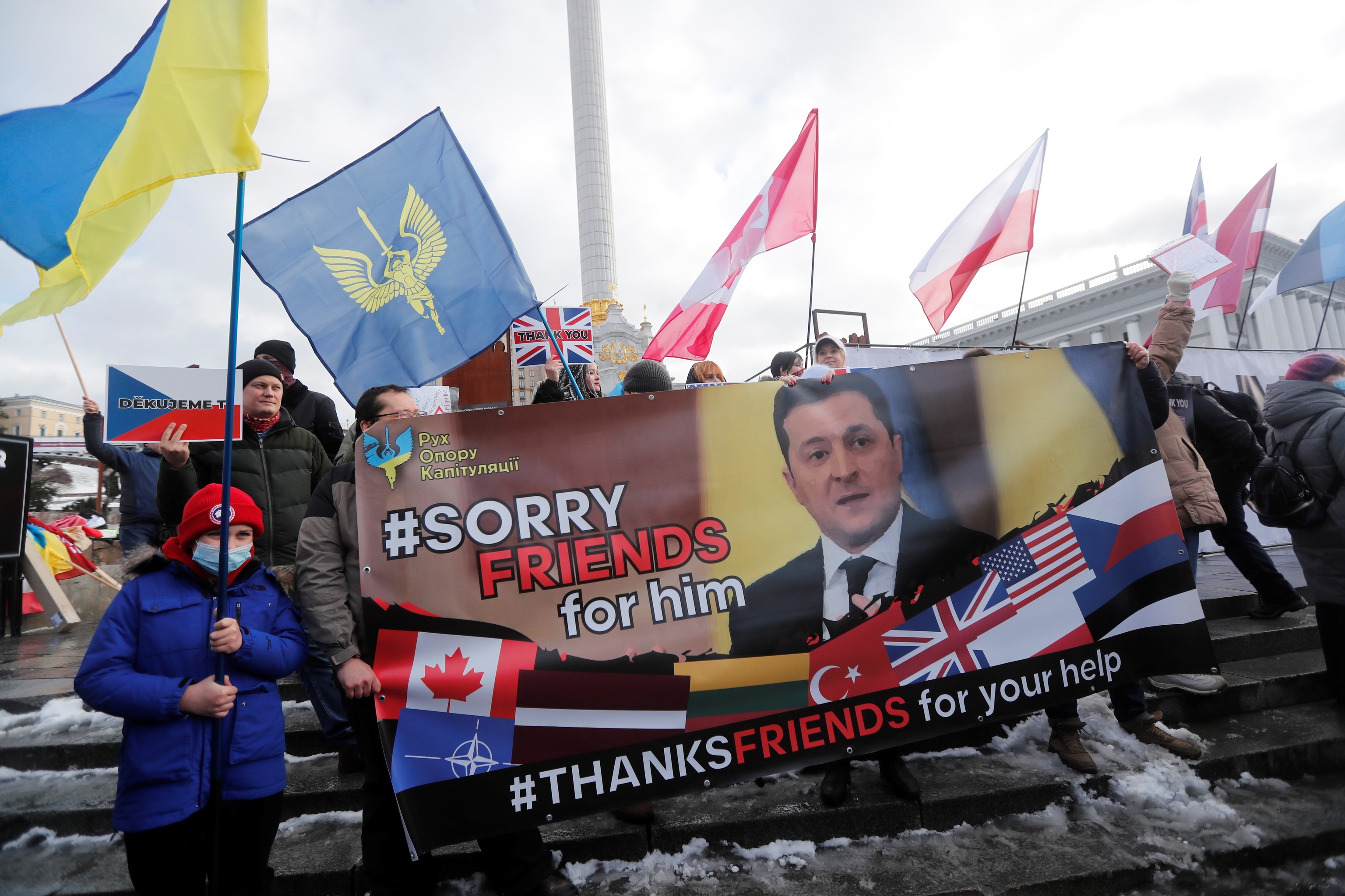 "Perdonadnos por él", leyenda en una pancarta contra el presidente ucraniano, Volodímir Zelenski, en la manifestación en Kiev por el apoyo exterior a Ucrania.
