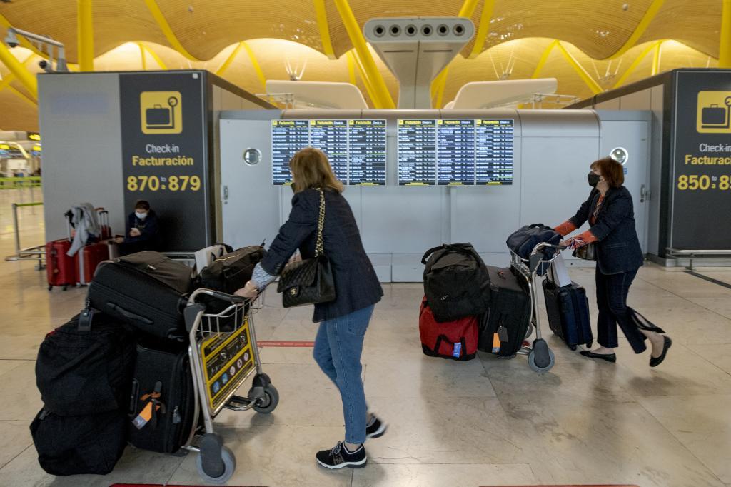 Pasajeros empujan sus maletas en carros, mientras transitan en el terminal cuatro del aeropuerto Adolfo Surez de Madrid-Barajas.