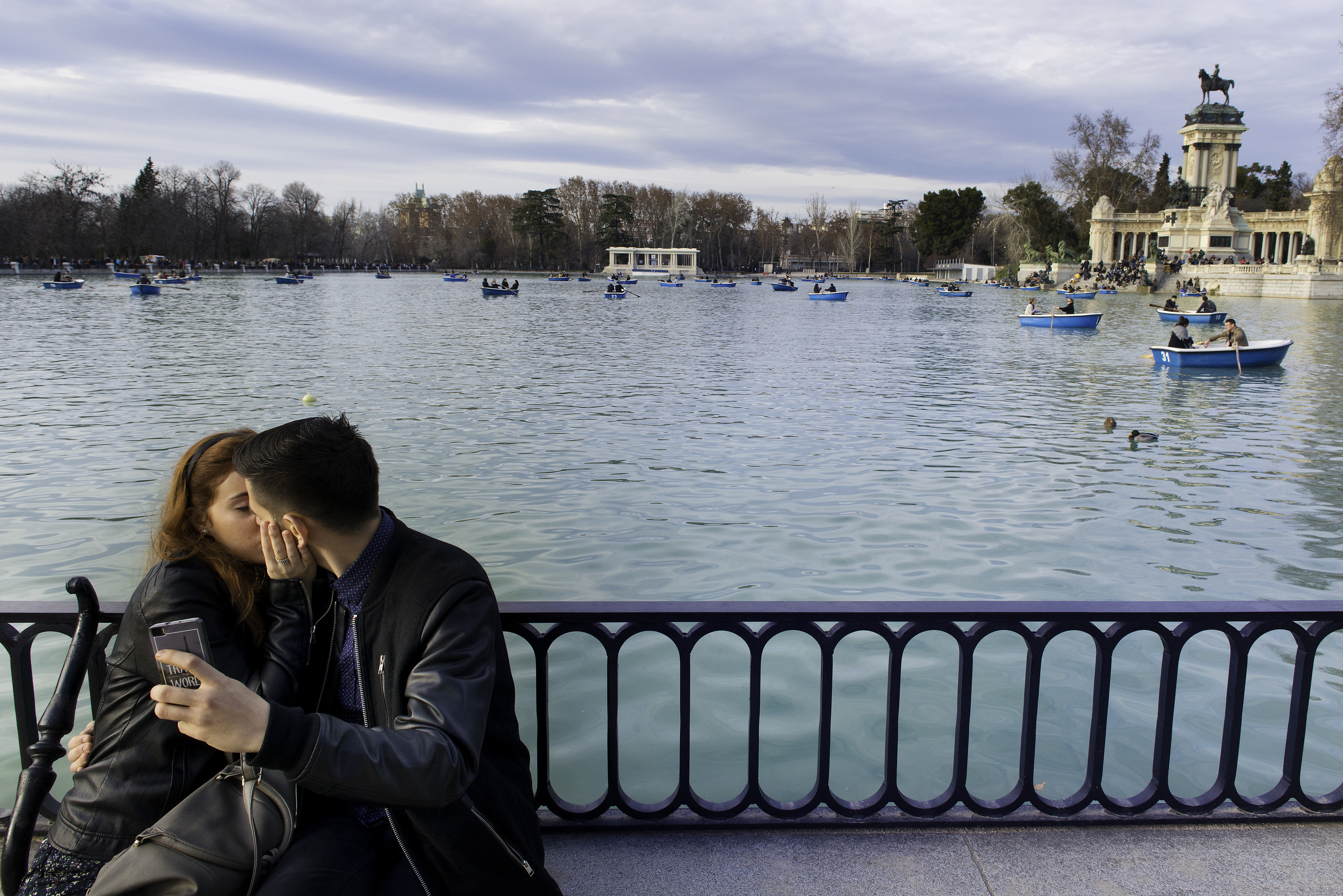 Una pareja sentada frente al estanque de El Retiro.