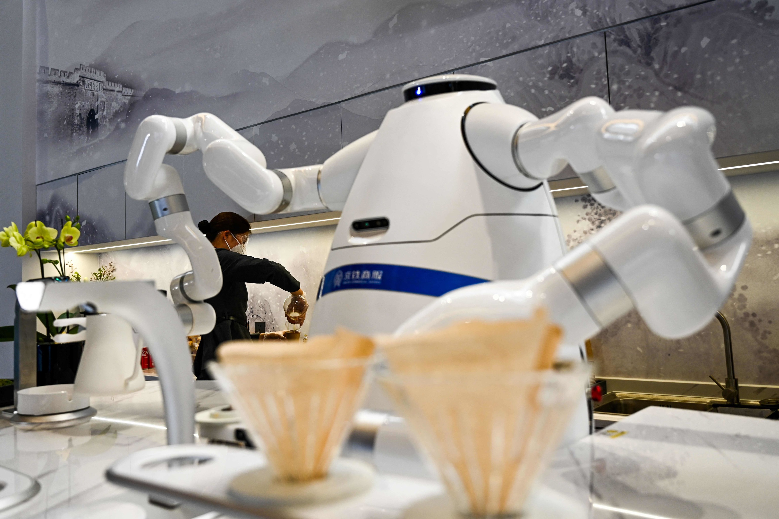 Un robot sirve caf en el recinto de los Juegos.