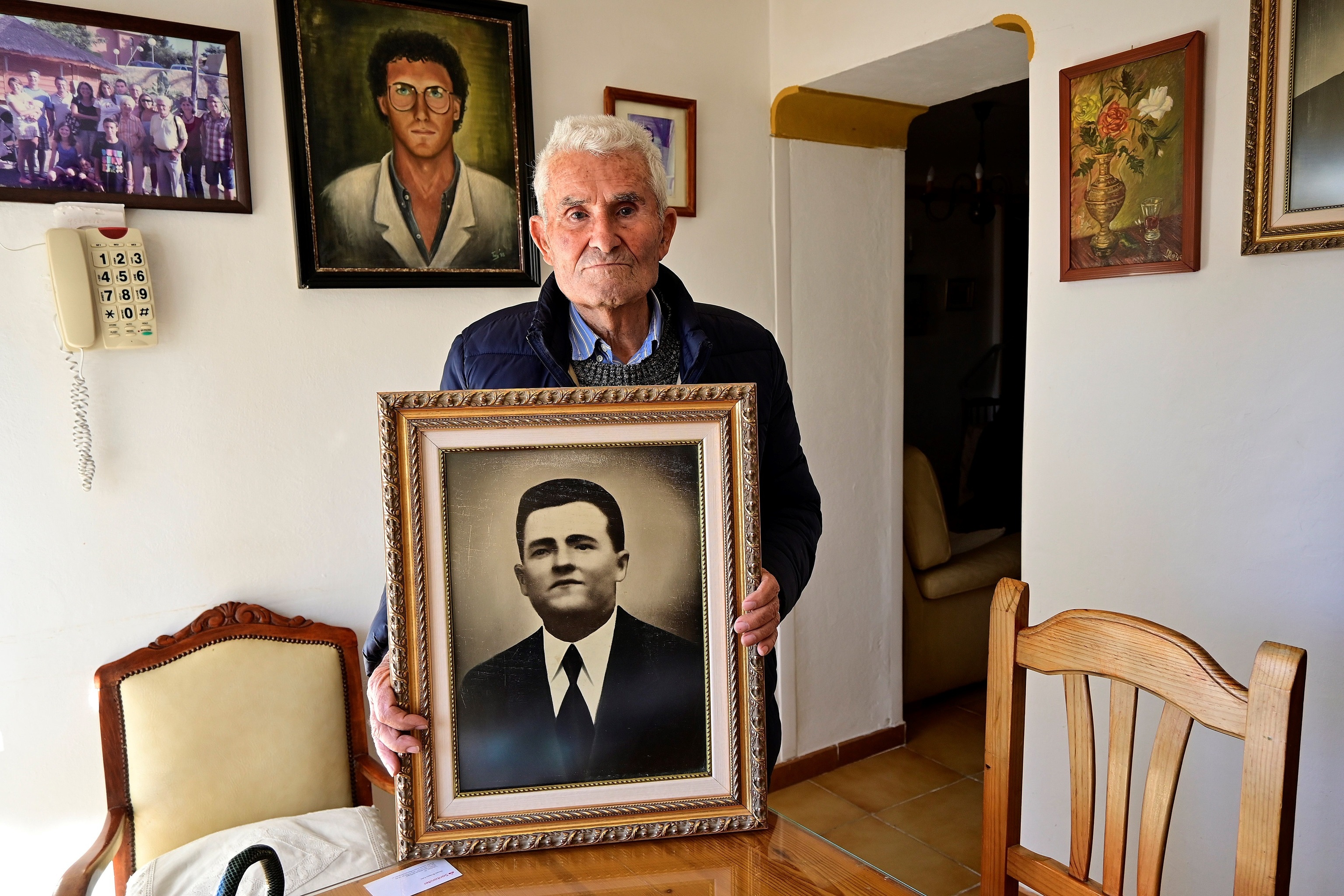 Pepe Alarcn Garca, de 90 aos, con el retrato de su padre en su casa en Vlez-Mlaga.