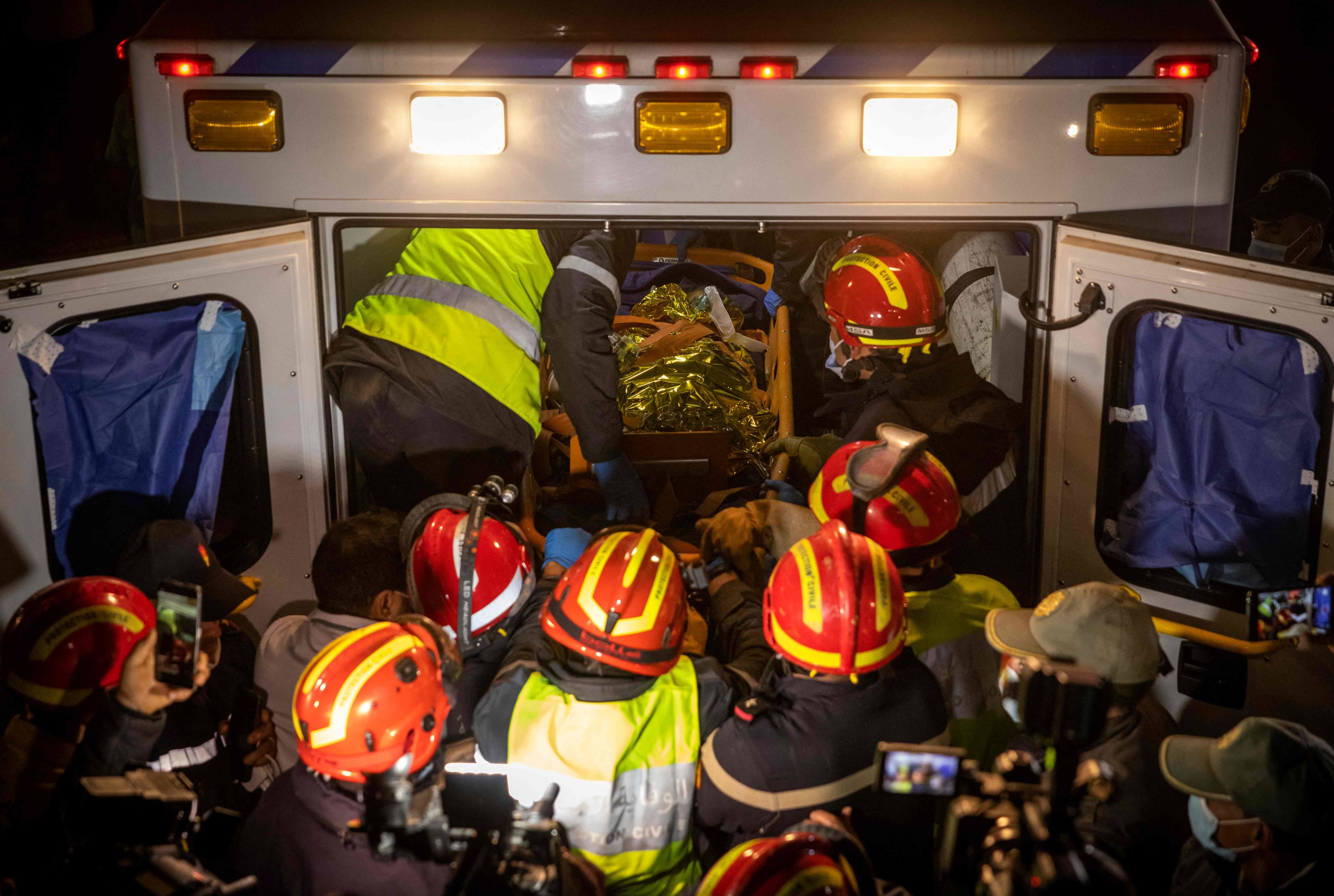 Moroccan emergency services teams carry five-year-old  lt;HIT gt;Rayan lt;/HIT gt; Oram into an ambulance after pulling him from a well shaft he fell into on February 1, in the remote village of Ighrane in the rural northern province of Chefchaouen on February 5, 2022. - Moroccan rescue crews found the five-year-old boy dead at the bottom of a well late on Februay 5, in a tragic end to a painstaking five-day operation that has gripped the nation. (Photo by Fadel SENNA / AFP)