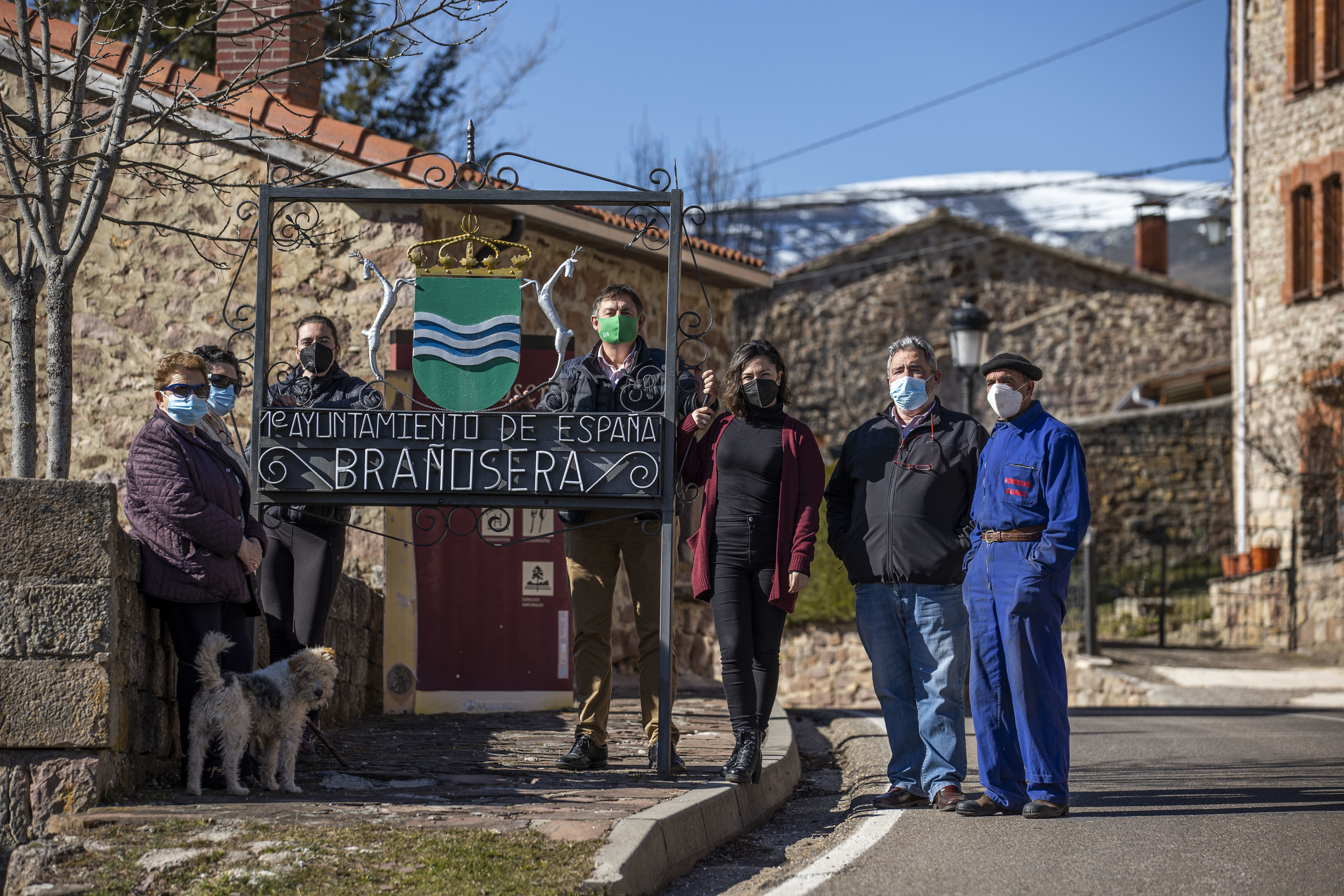 Vecinos de Braosera (Palencia), el mircoles ante el cartel a la entrada del pueblo que seala que es el primer Ayuntamiento de la historia de Espaa.