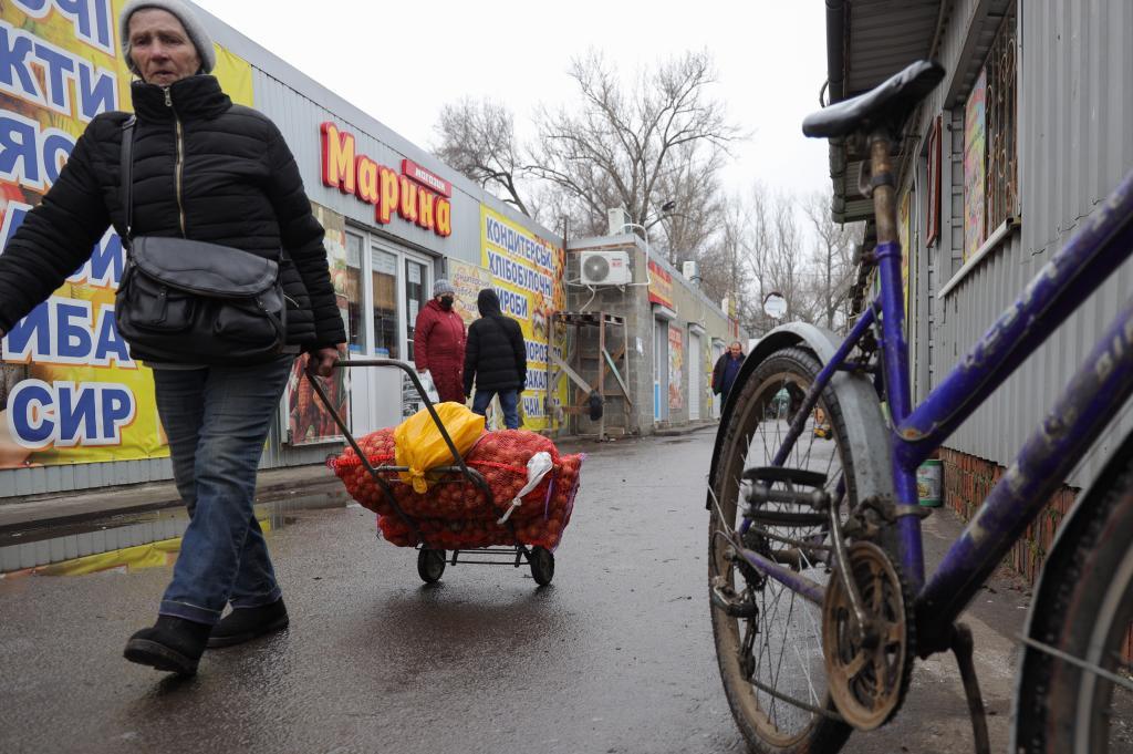 Una mujer carga con patatas en la pequea ciudad de New York, cerca de Donetsk.