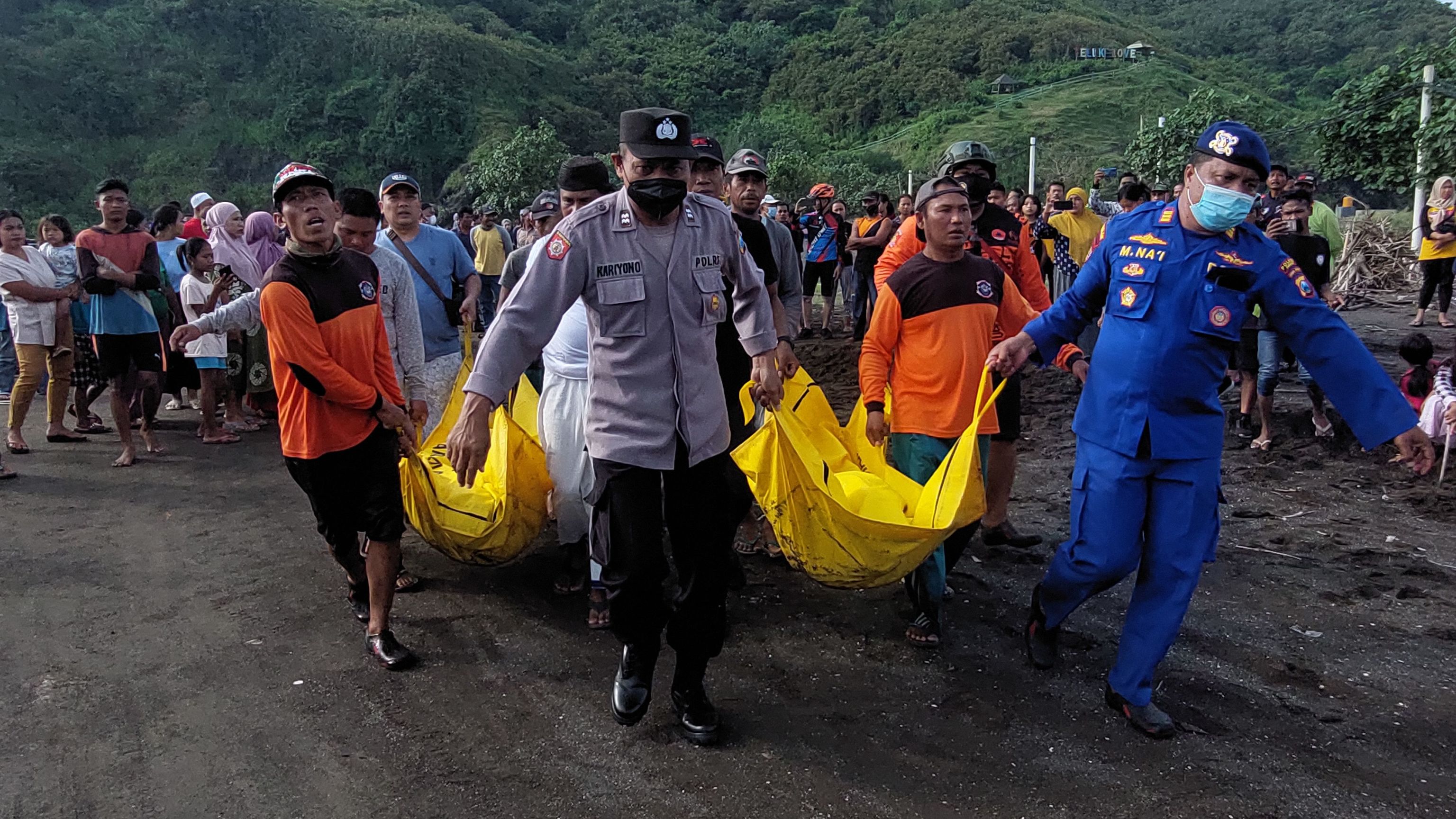 Miembros indonesios de un equipo de bsqueda y rescate evacuan cadveres durante una operacin de bsqueda tras un accidente en un ritual de playa que mat a diez personas en Jember, Java Oriental, el 13 de febrero de 2022.