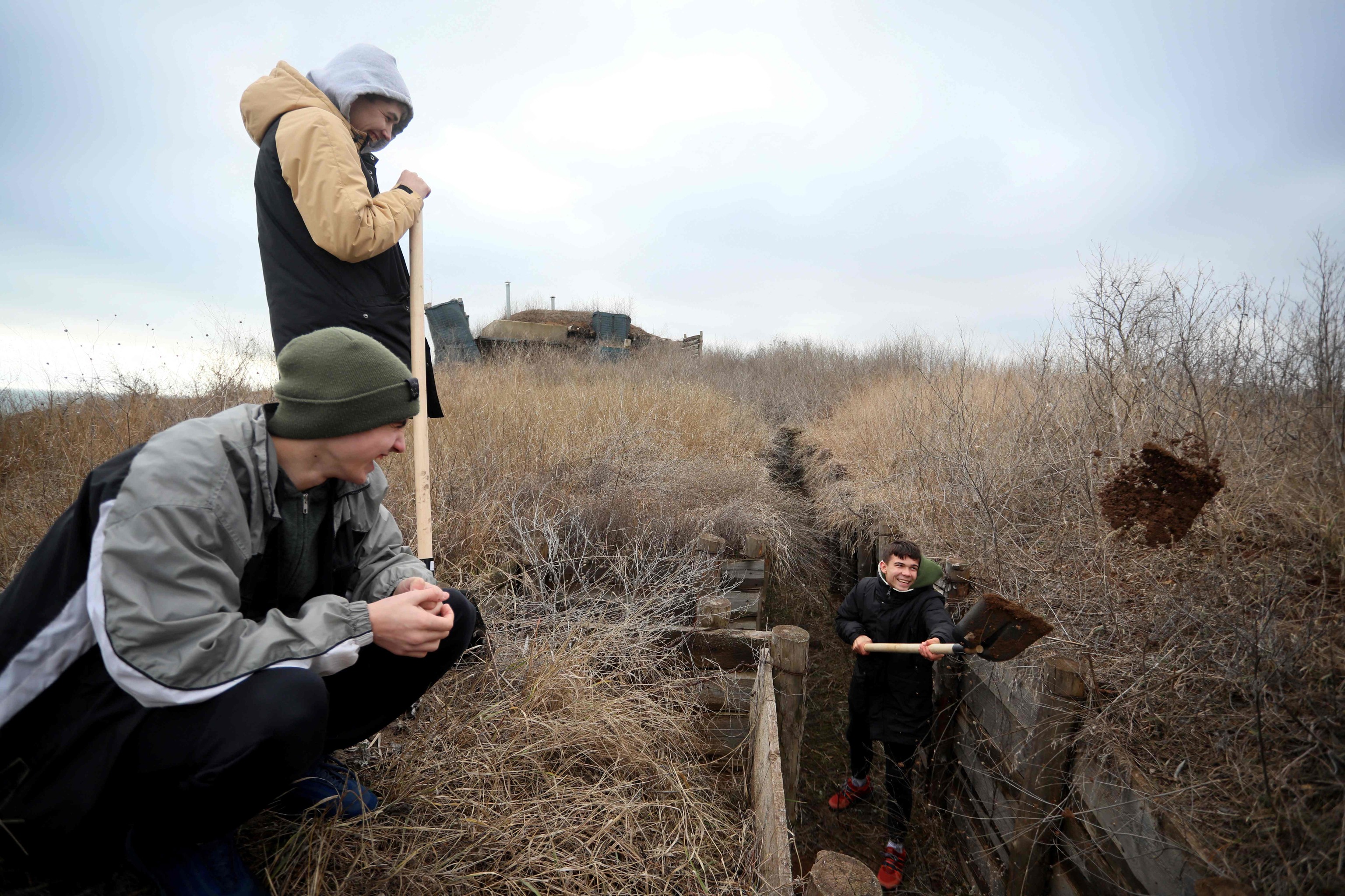 Adolescentes ucranianos cavan trincheras cerca de la aldea de Chervone, en la región de Mariupol, en el este de Ucrania.
