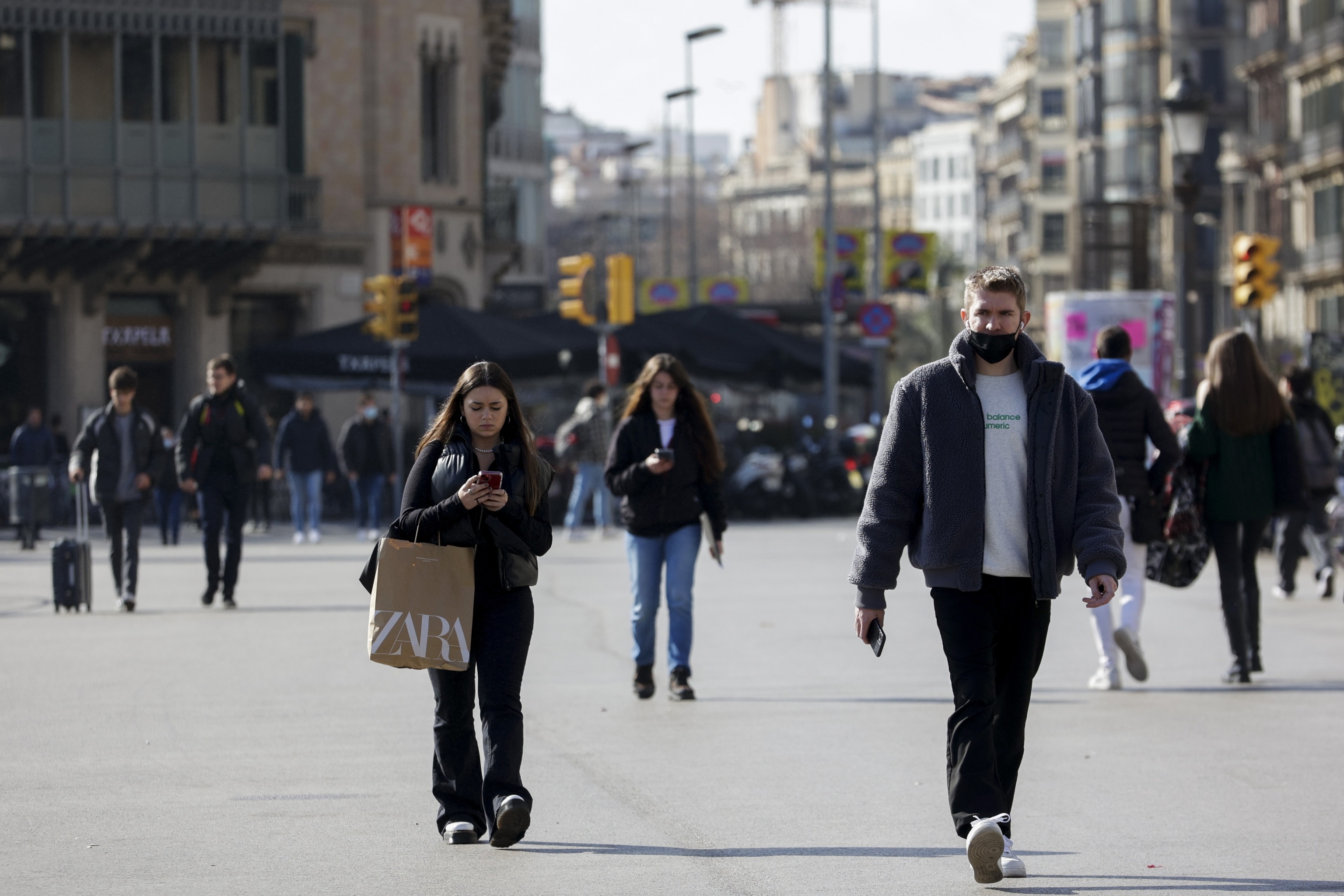 Varias personas pasean por el centro de Barcelona.