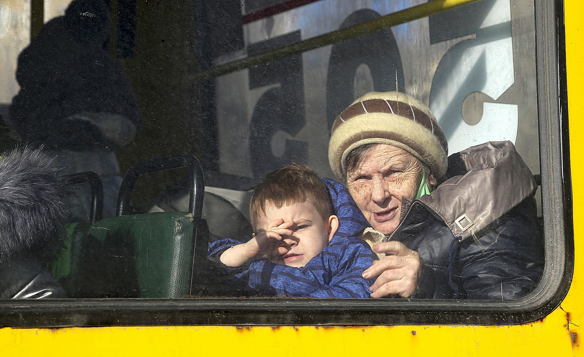 Una anciana y un niño en un autobús de evacuación, en Donetsk.