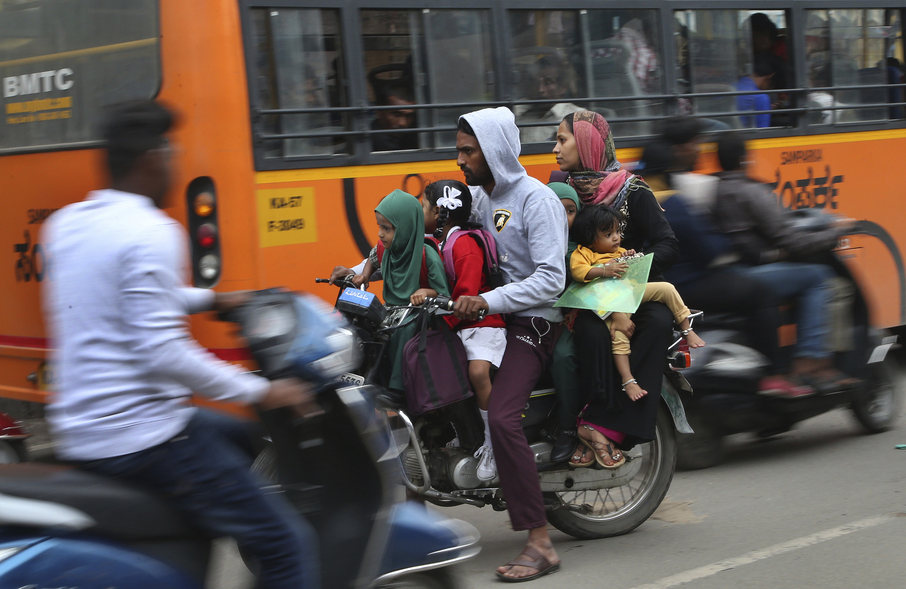 Un motorista y un autobs se cruzan en Bangalore (India).