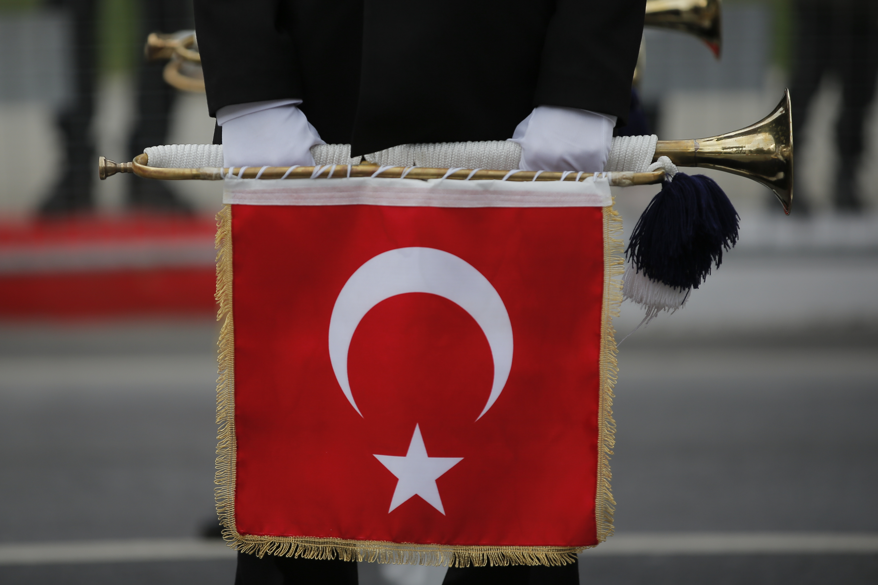 Un soldado turco con una trompeta con la bandera turca.