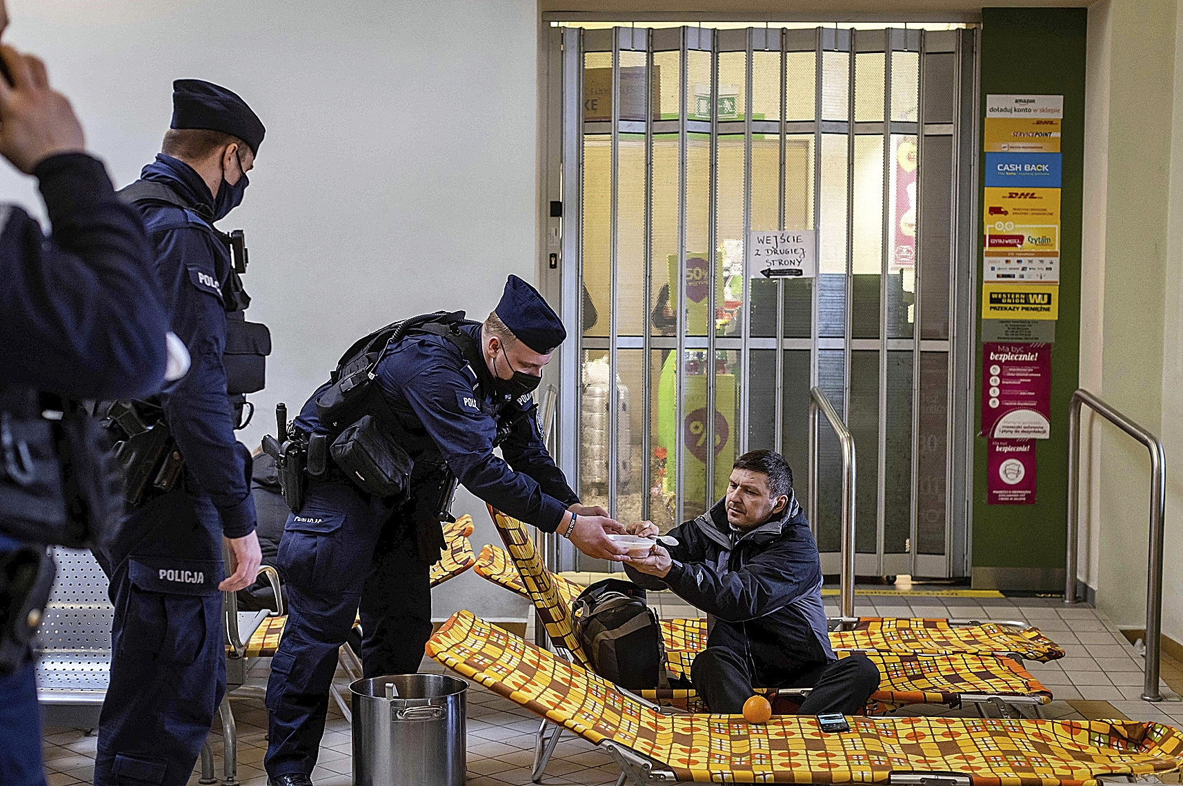 Oficiales de la polica sirven sopa a un ucraniano, en Przemysl (Polonia).