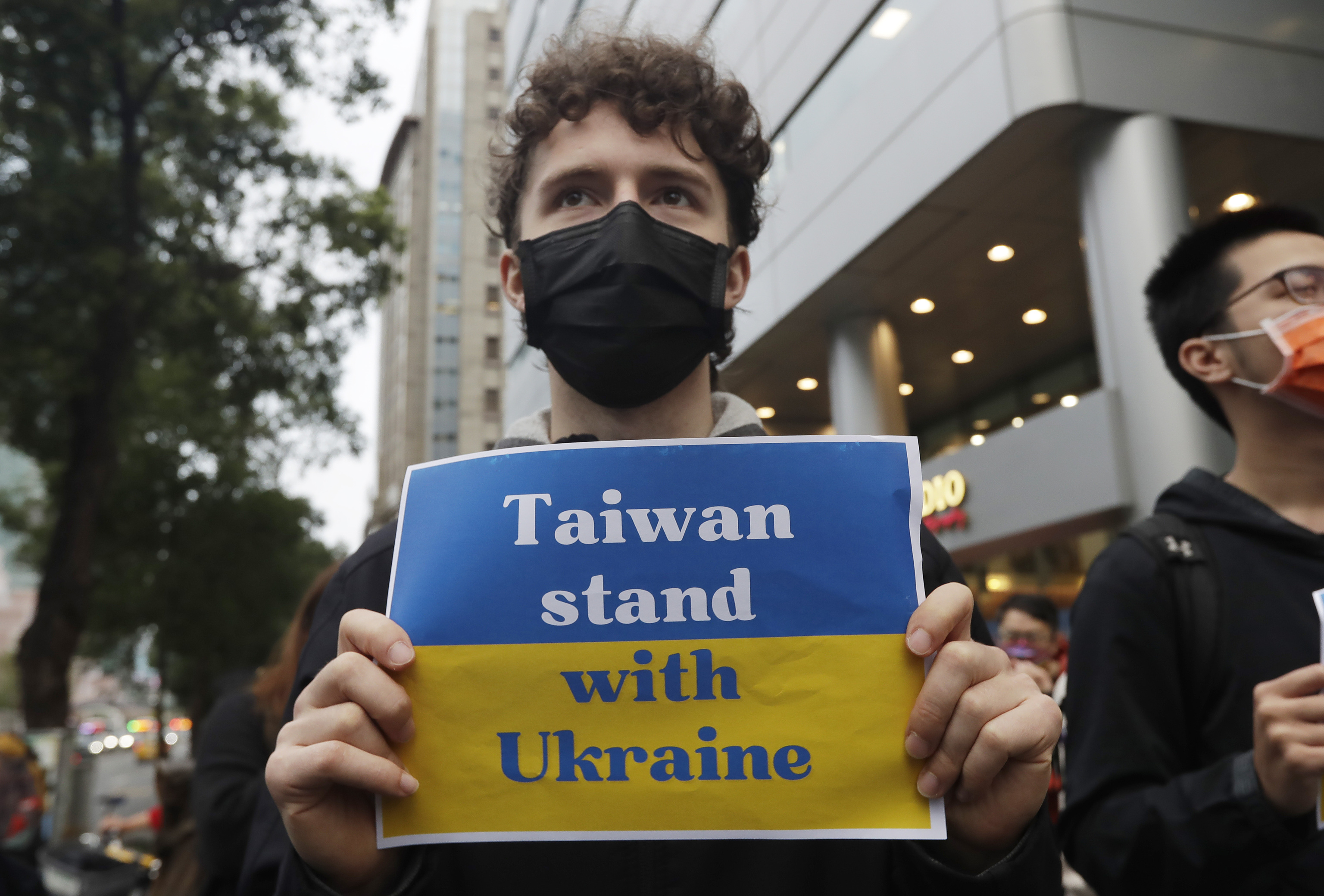 Un hombre sostiene un cartel con un mensaje de apoyo a Taiwan.