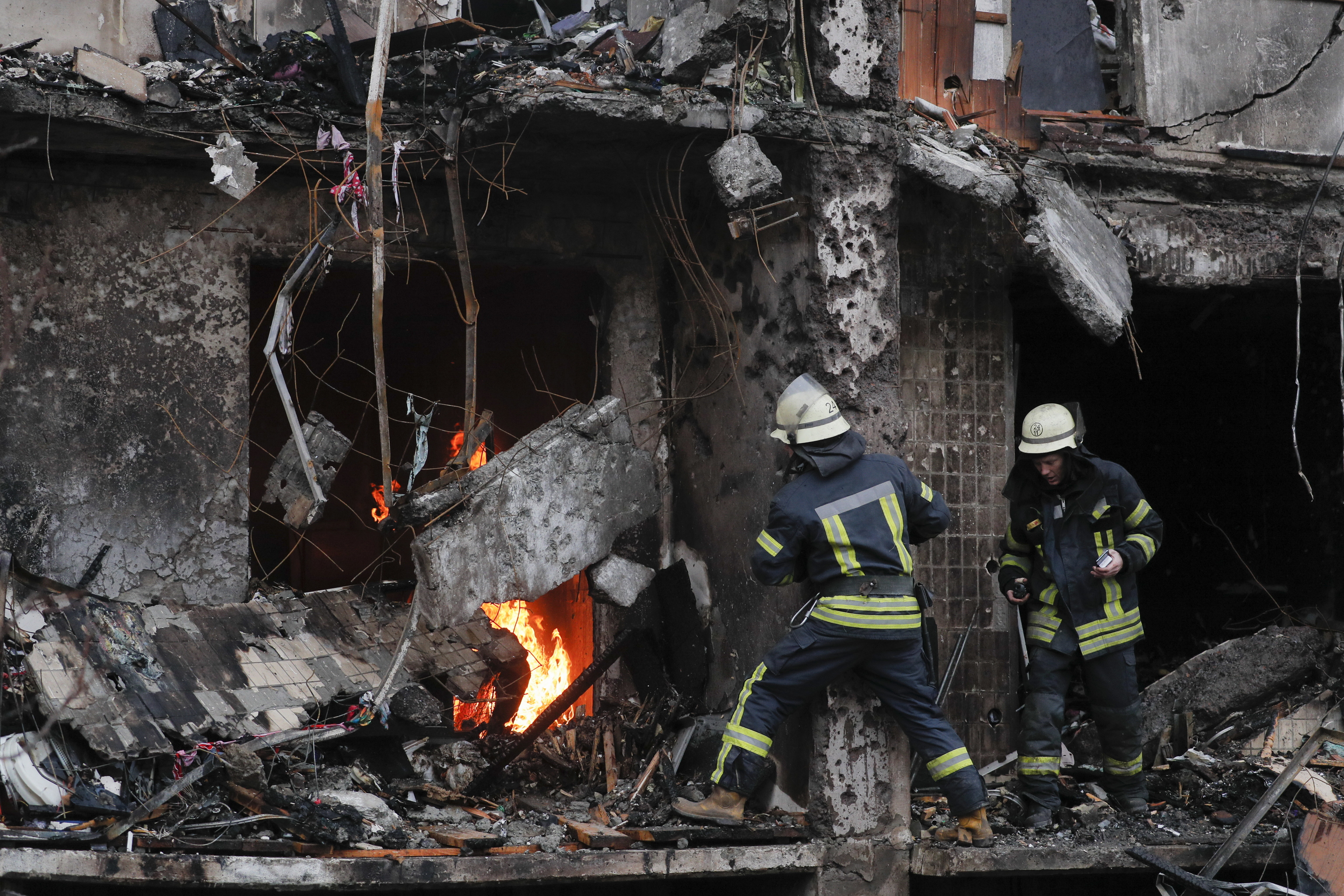Bomberos en edificios de Kiev atacados por Rusia.
