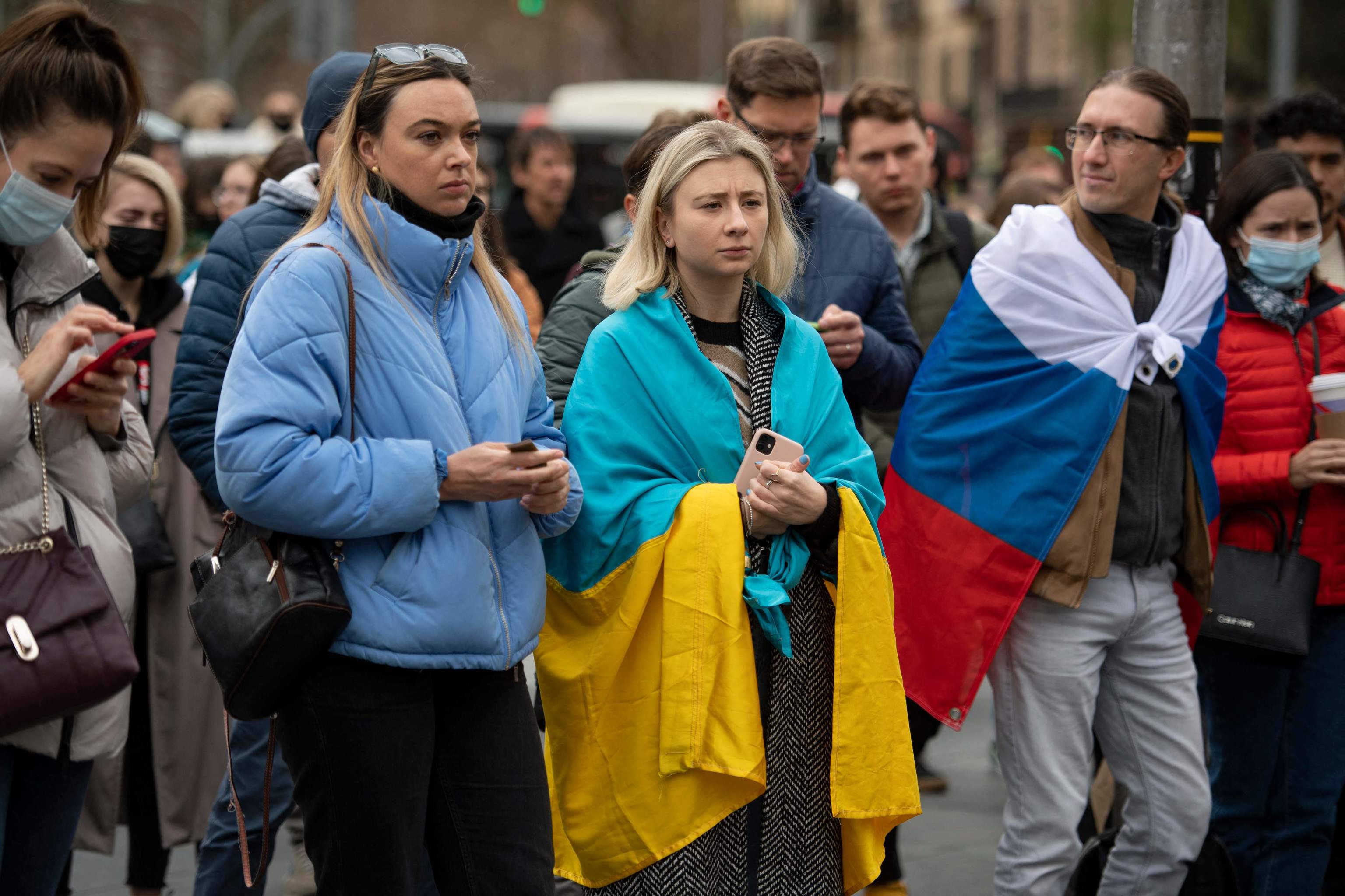 Manifestantes llevan una bandera ucraniana y otra rusa durante una protesta contra la operacin militar de Rusia en Ucrania, en Barcelona.