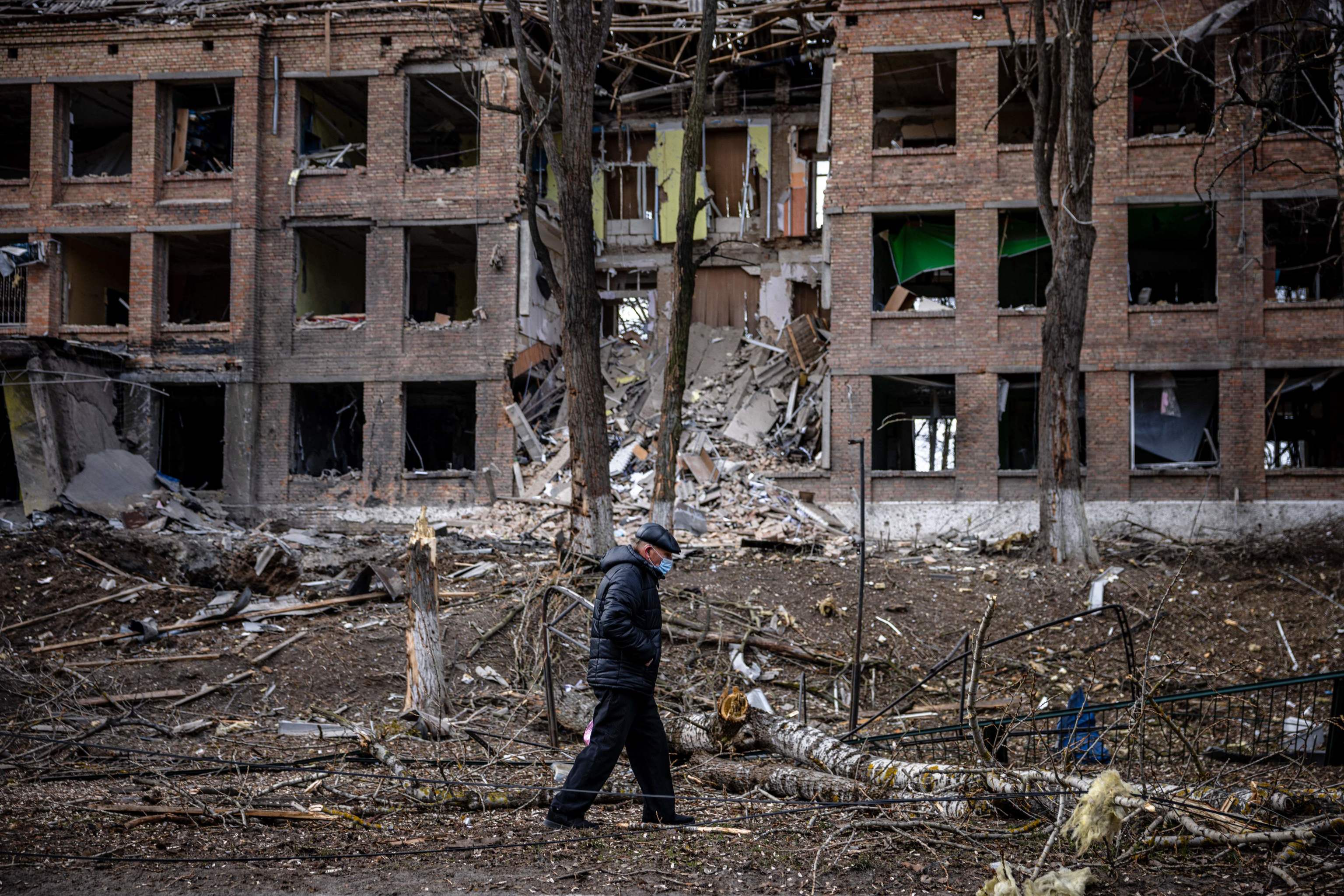 Un hombre camina delante de un edificio bombardeado en Vasylkiv, cerca de Kiev.