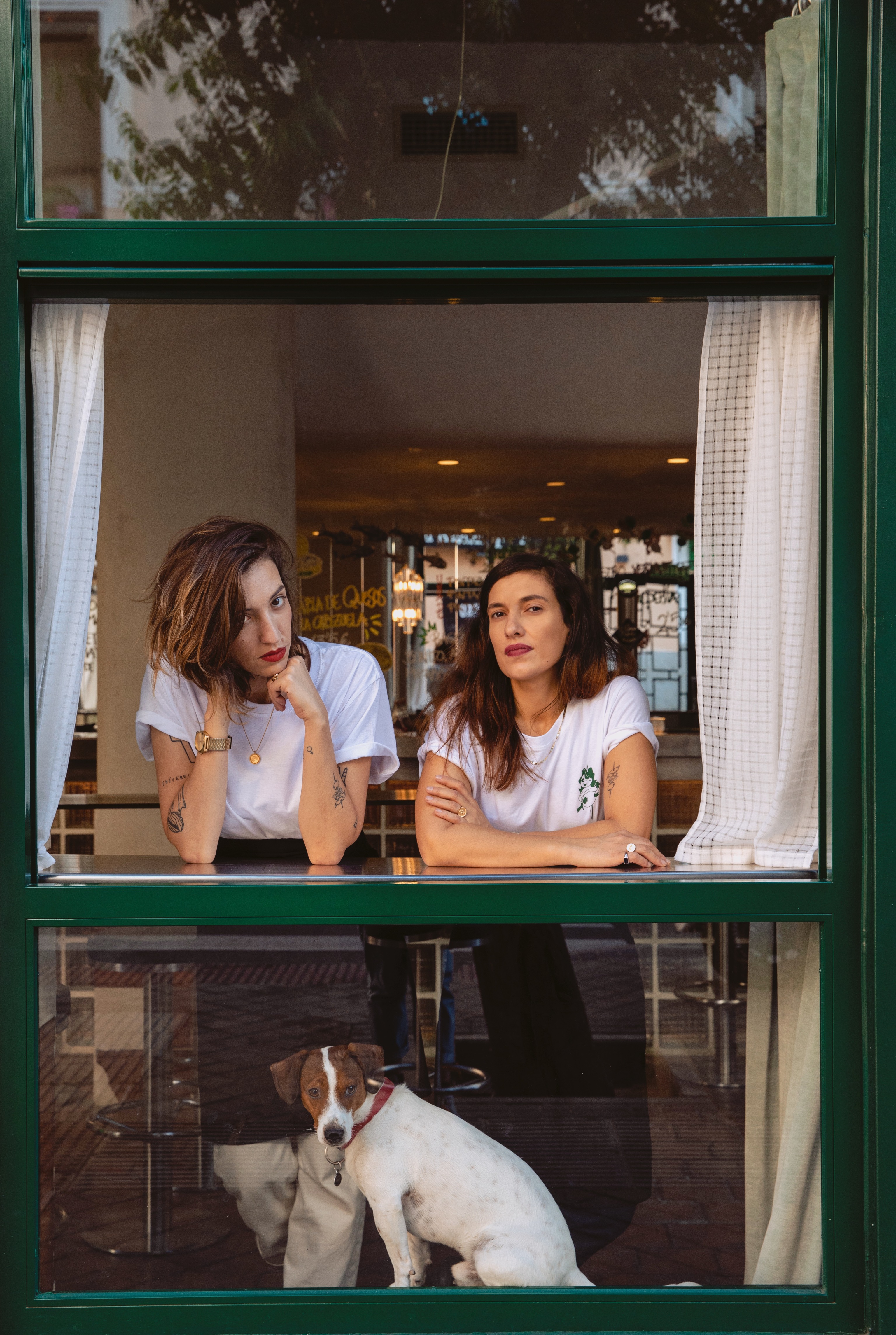 Yajaira (a la izquierda) y Cristina en la ventana de su bar, en pleno barrio de la Latina.