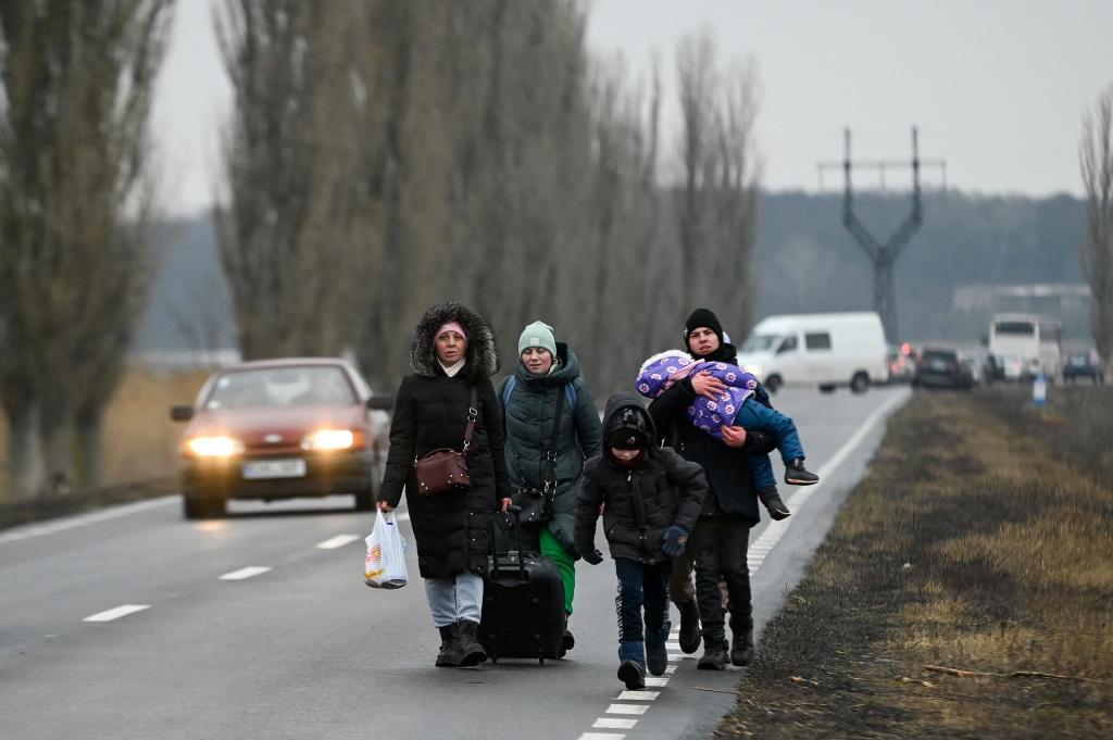 Refugiados ucranianos en la carretera tras cruzar el puesto fronterizo en Palanca, entre Ucrania y Moldavia.