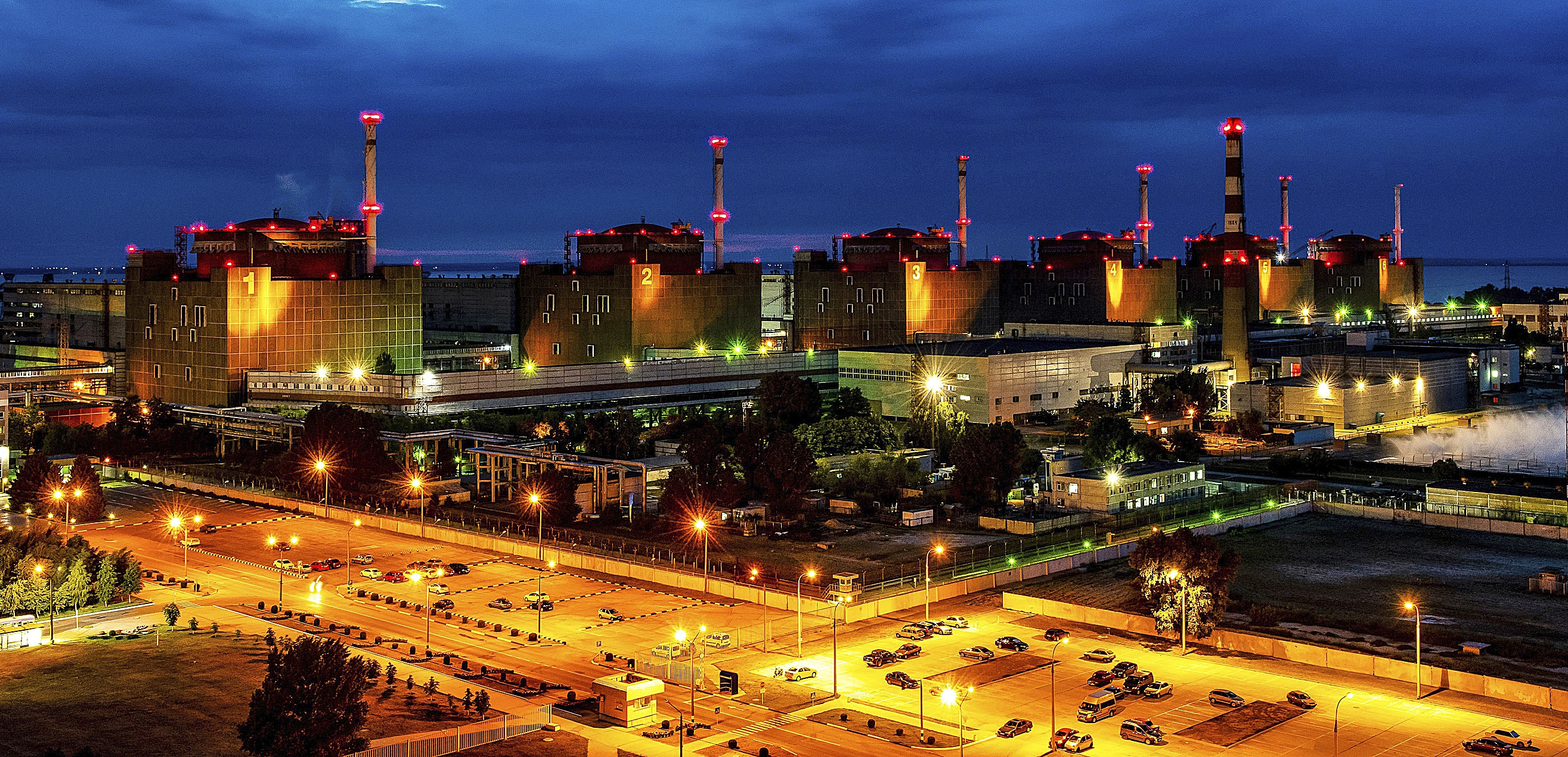 Las unidades generadoras y las instalaciones de la central nuclear de Zaporizhzhia se iluminan por la noche, Enerhodar, región de Zaporizhzhia, sureste de Ucrania