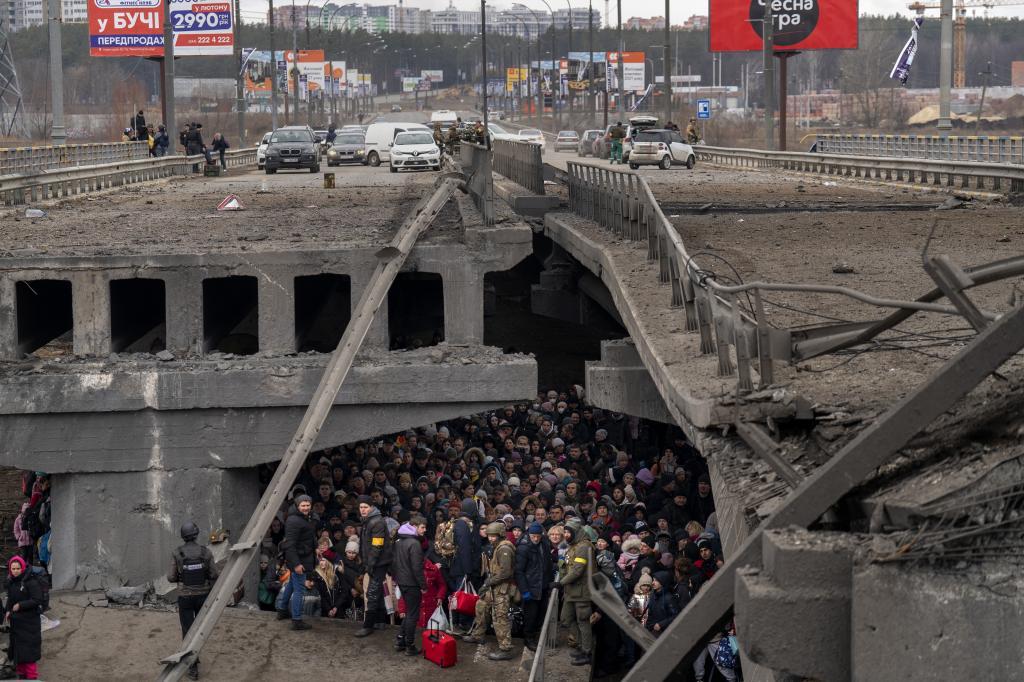 Multitud de ucranianos bajo un puente destruido en Irpin, a las afueras de Kiev.