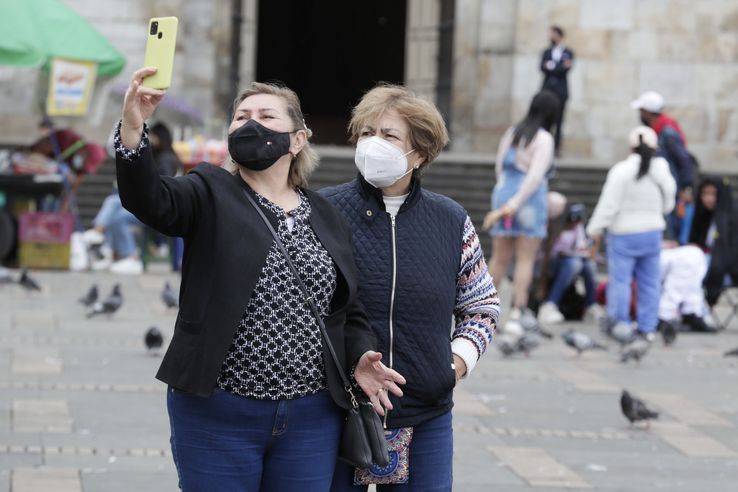 Dos mujeres con mascarilla por el coronavirus se toman un selfie.