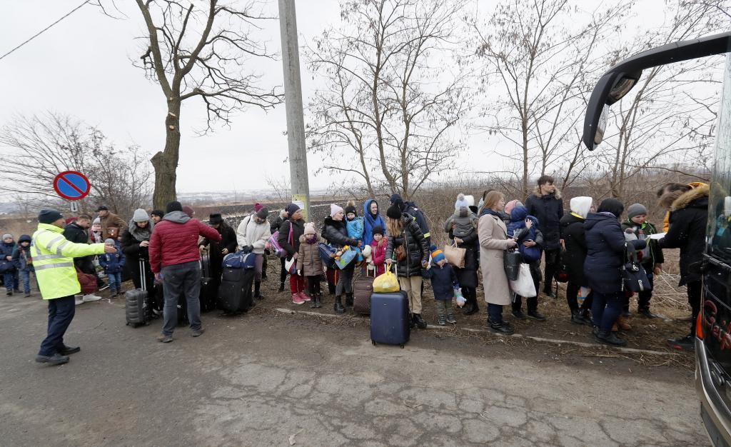 Refugiados ucranianos hacen cola para subir a un autobs que los llevar a Polonia.