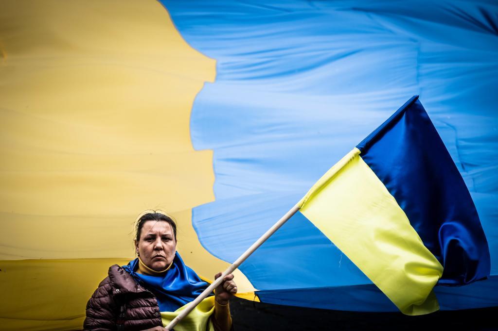 Una mujer sostiene una bandera de Ucrania, durante una protesta contra la guerra de Rusia.