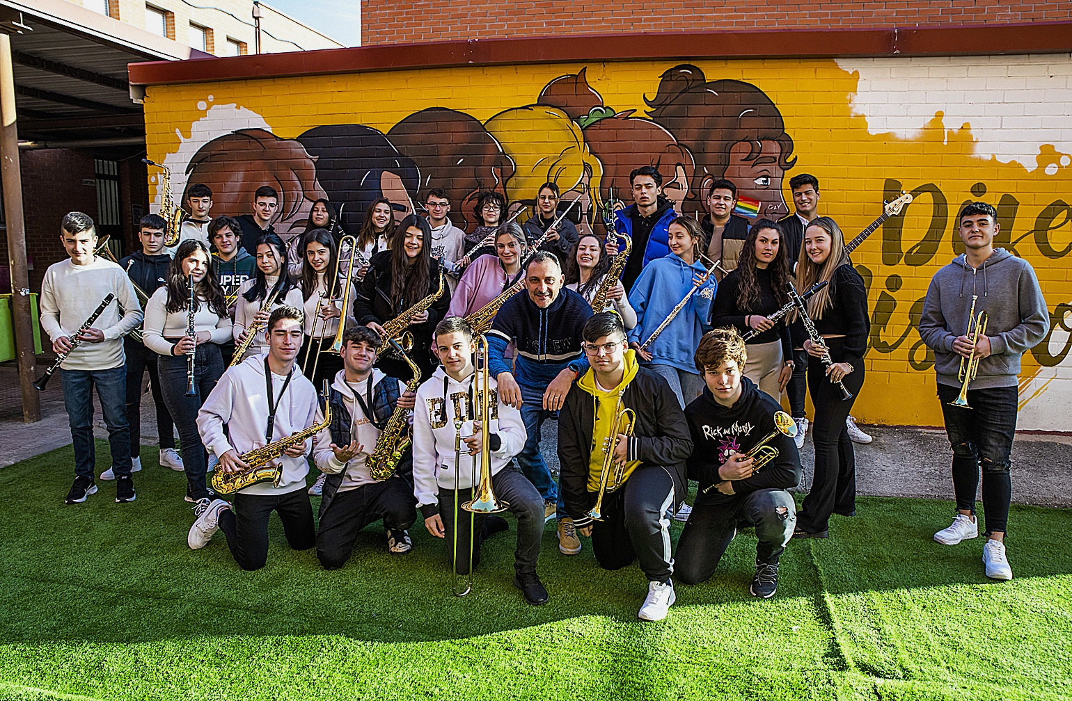 El profesor de música y saxofonista, Juan Ruiz, en el centro de la imagen, rodeado de alumnos que integan la banda del IES Rafael Alberti, de Coslada.