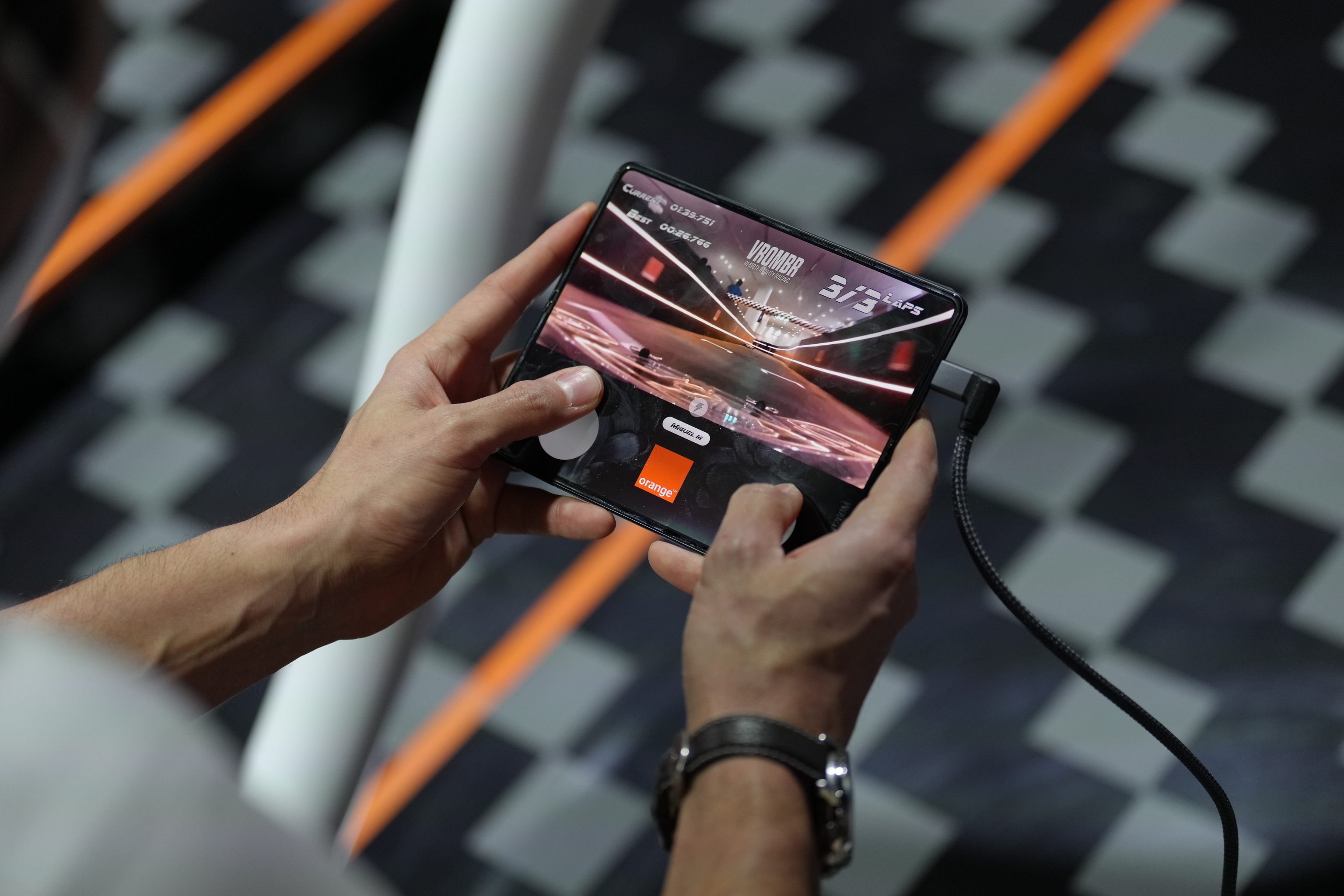 Un visitante prueba un dispositivo de videojuegos 5G en el stand de Orange del Mobile World Congress 2022.