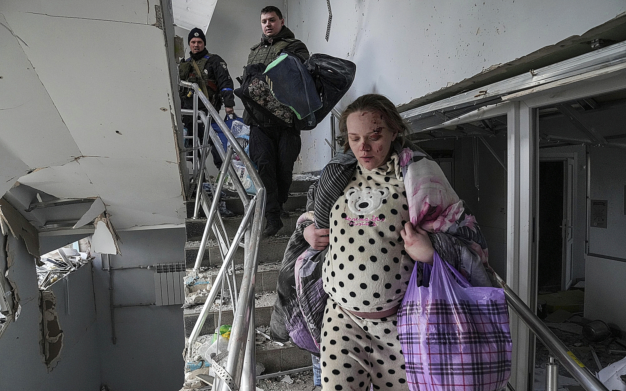Una embarazada huye del hospital materno-infatil de Mariupol.
