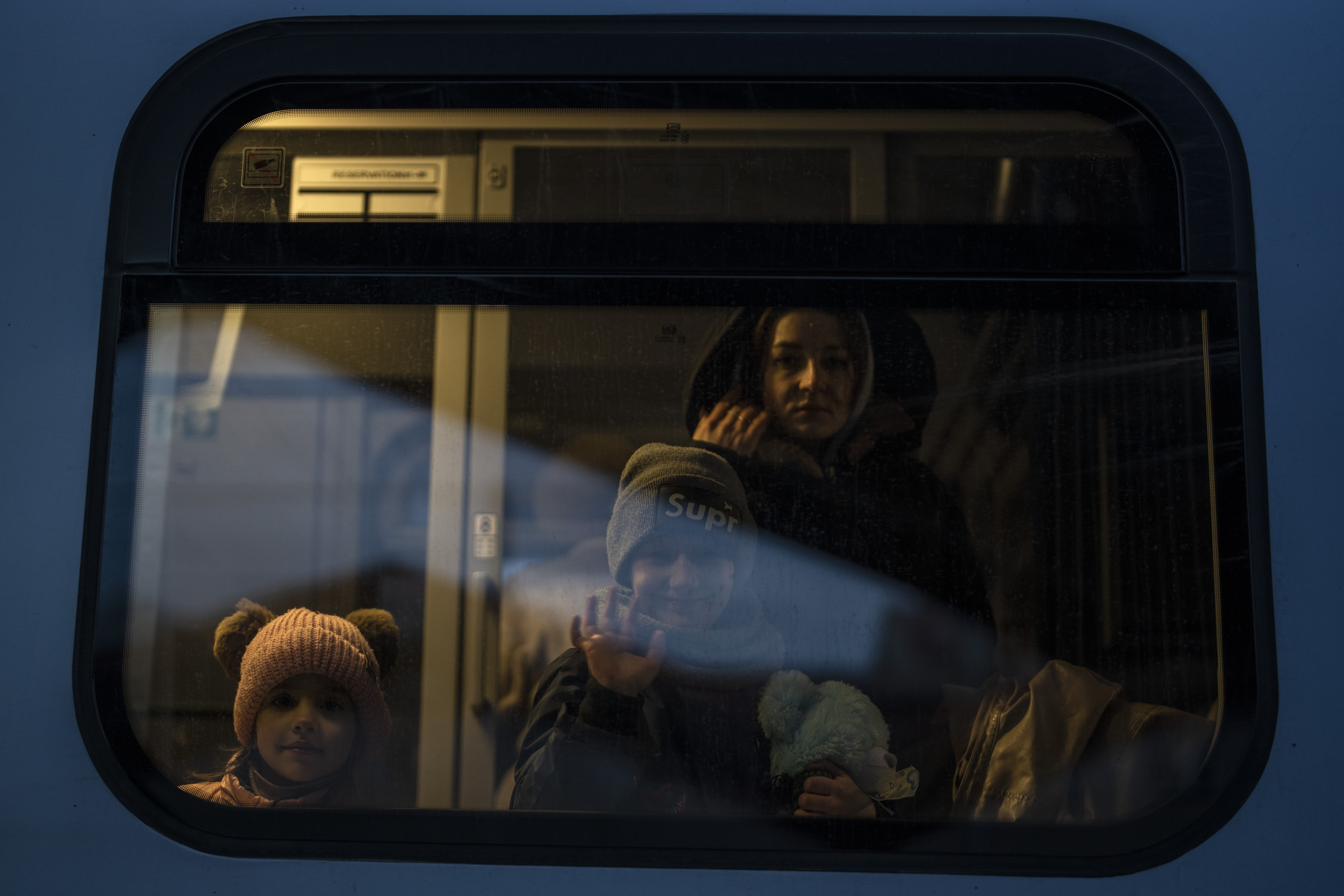 Un nio que huy de la guerra de la vecina Ucrania saluda mientras mira con otros refugiados desde un tren que va a Varsovia, en la estacin de tren de Przemysl, Polonia, el jueves 10 de marzo de 2022. Funcionarios de la ONU dijeron que la embestida rusa ha obligado a 2 millones de personas a huir de Ucrania.
