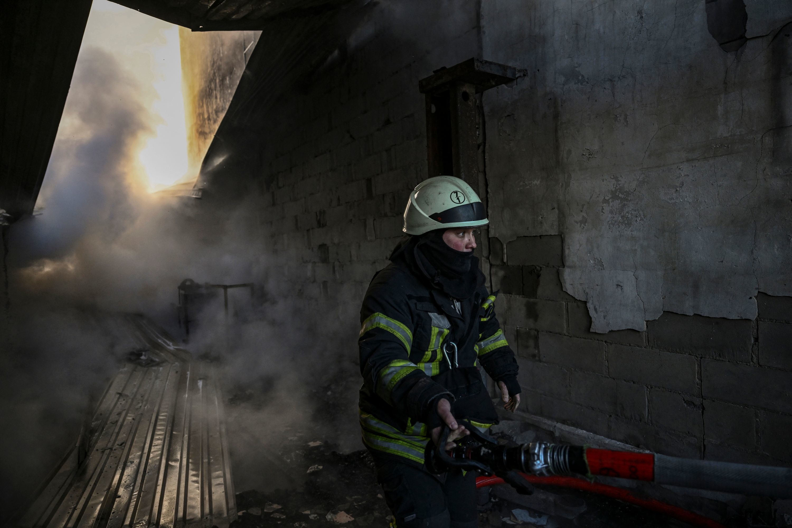 Bomberos ucraniana sofocan un incendio por los ataques a las afueras de Kiev.