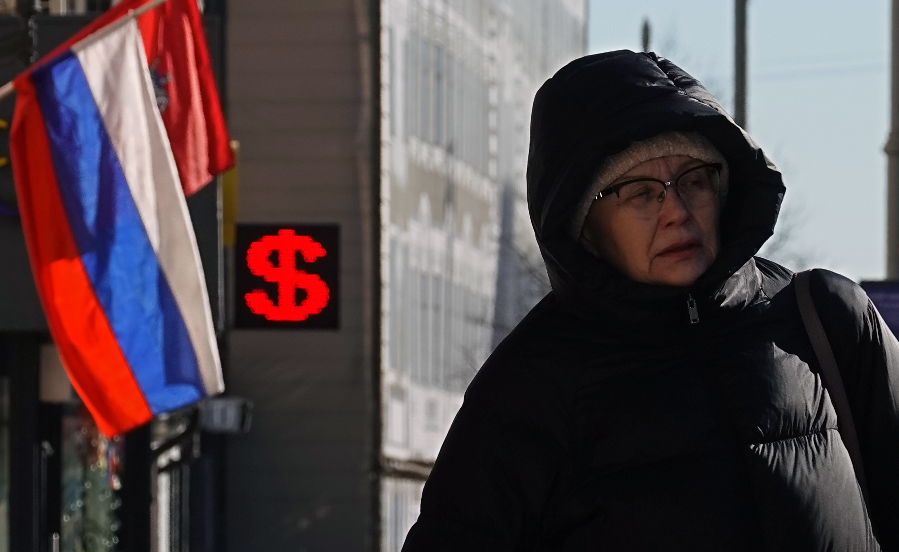 Una mujer pasa ante un cartel con el símbolo del dólar en una casa de cambio de Moscú.