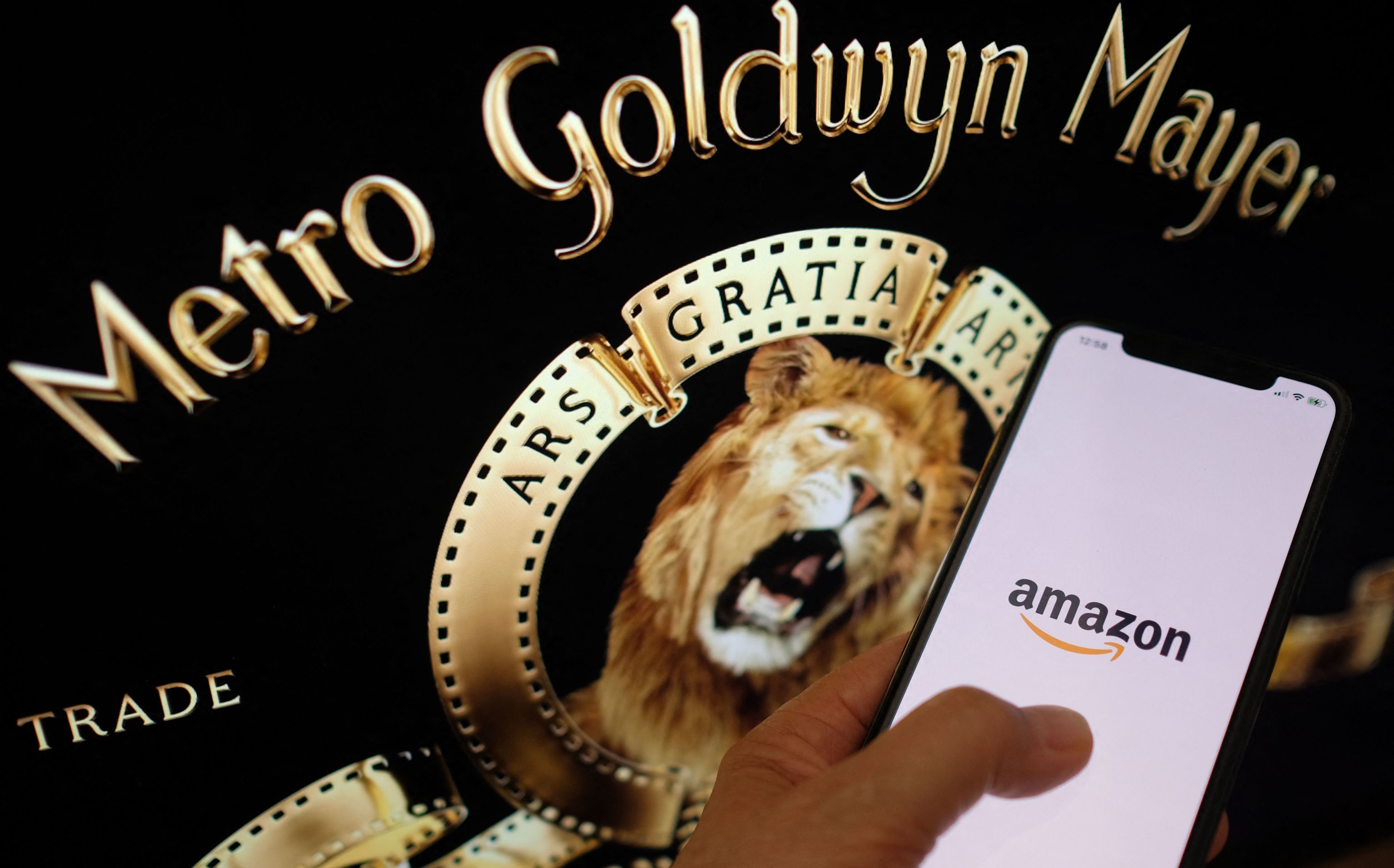 El logo de Amazon en un smartphone junto al de la GMG.