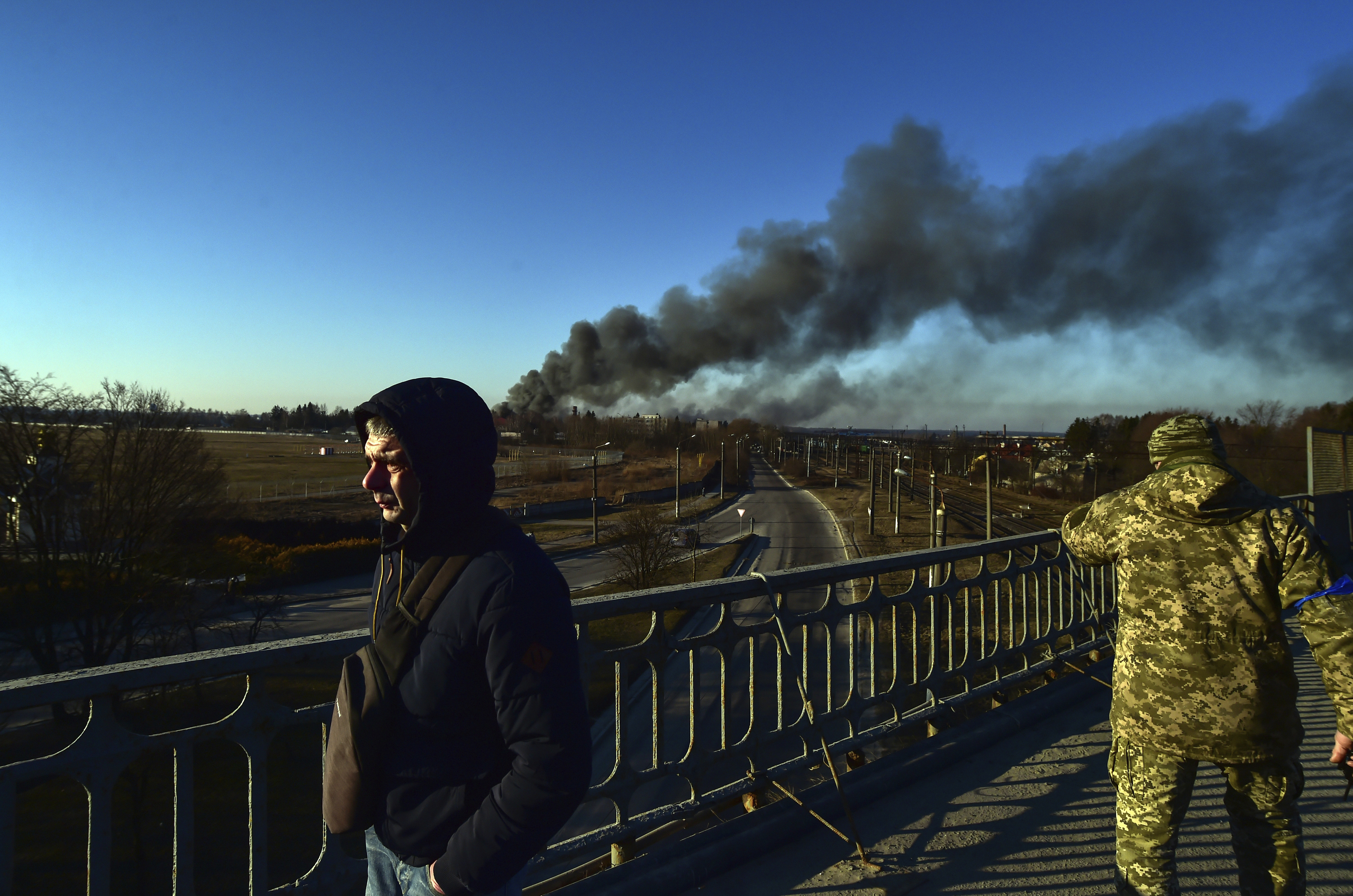 Un soldado ucraniano observa cómo se eleva el humo después de una explosión cerca del aeropuerto, en Leópolis, Ucrania.