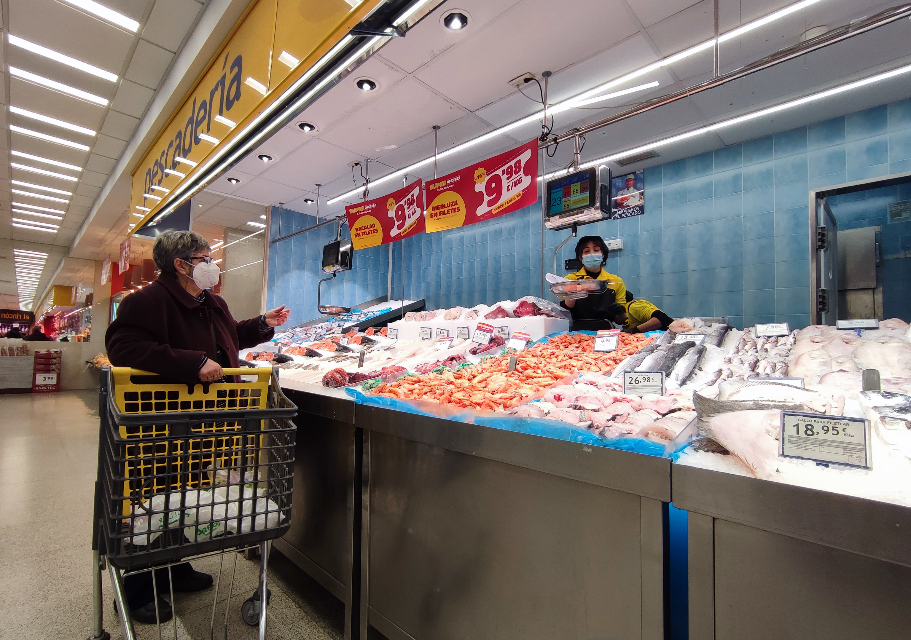 Varias personas compran pescado y mariscos en un supermercado de Madrid.