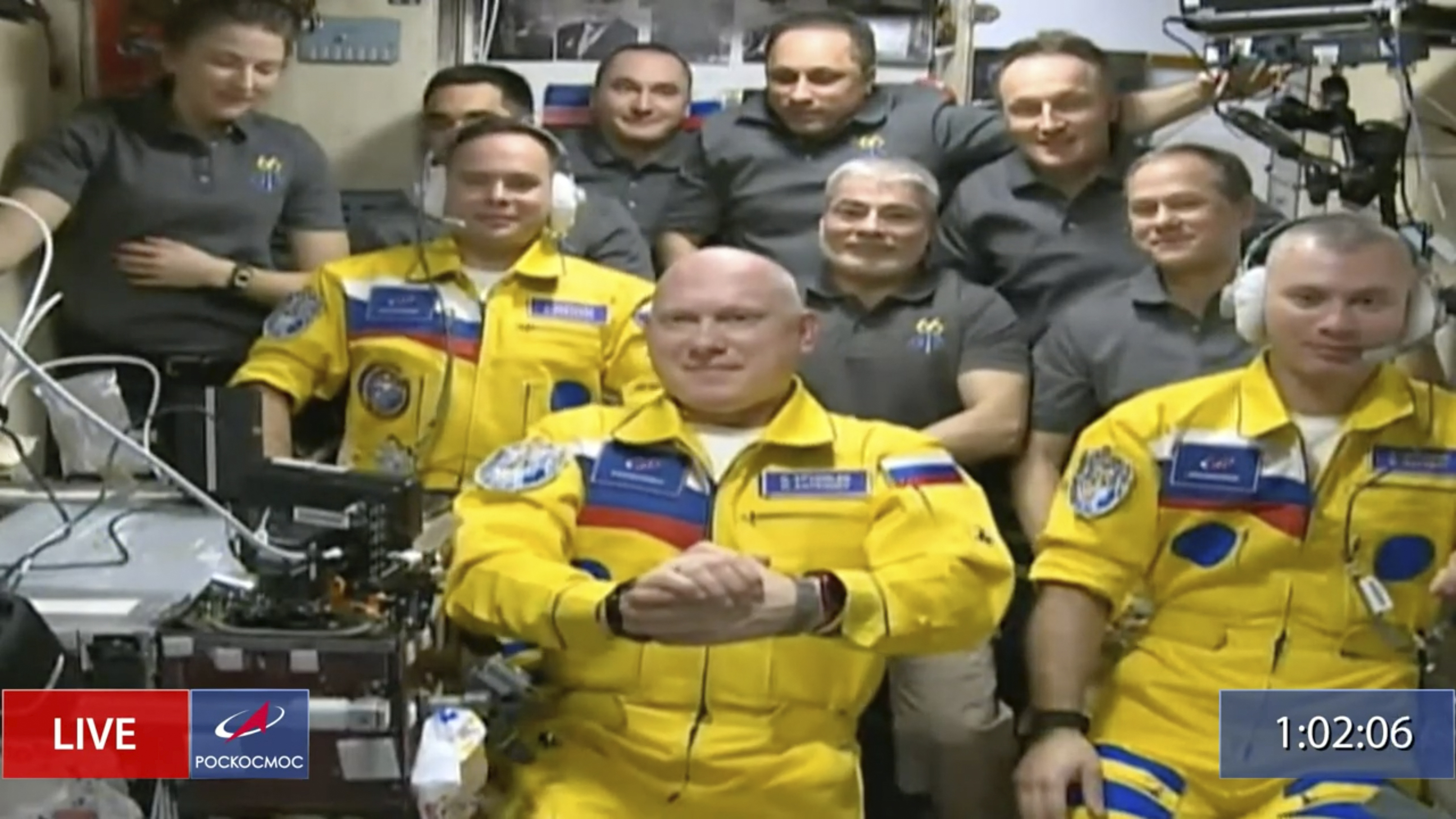 Sergey Korsakov, Oleg Artemyev y Denis Matveyev, con traje amarillo, durante la ceremonia de bienvenida en la ISS
