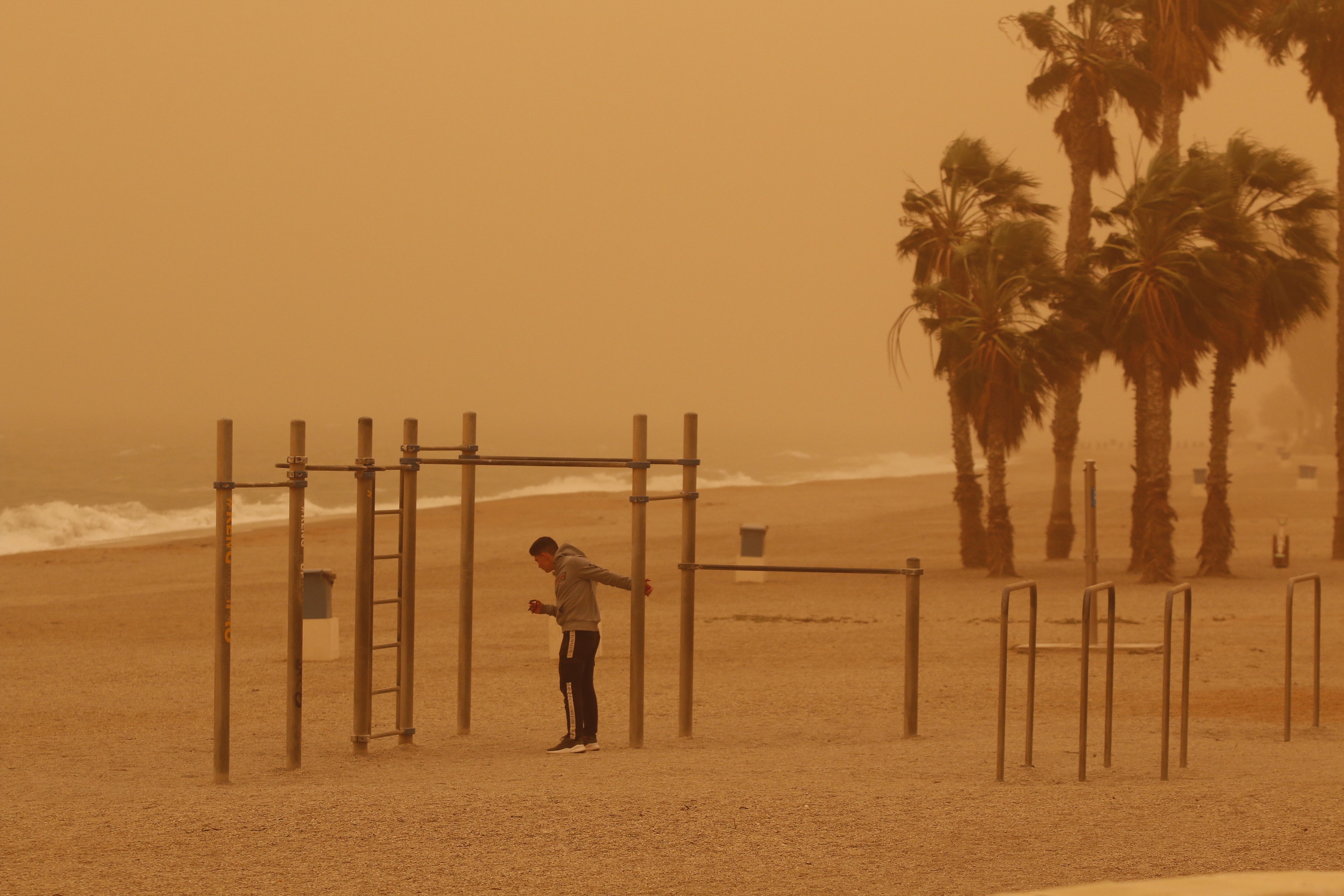 Un joven hace deporte en la playa de Aguadulce, Roquetas de Mar ( Almera) bajo la intensa calima.