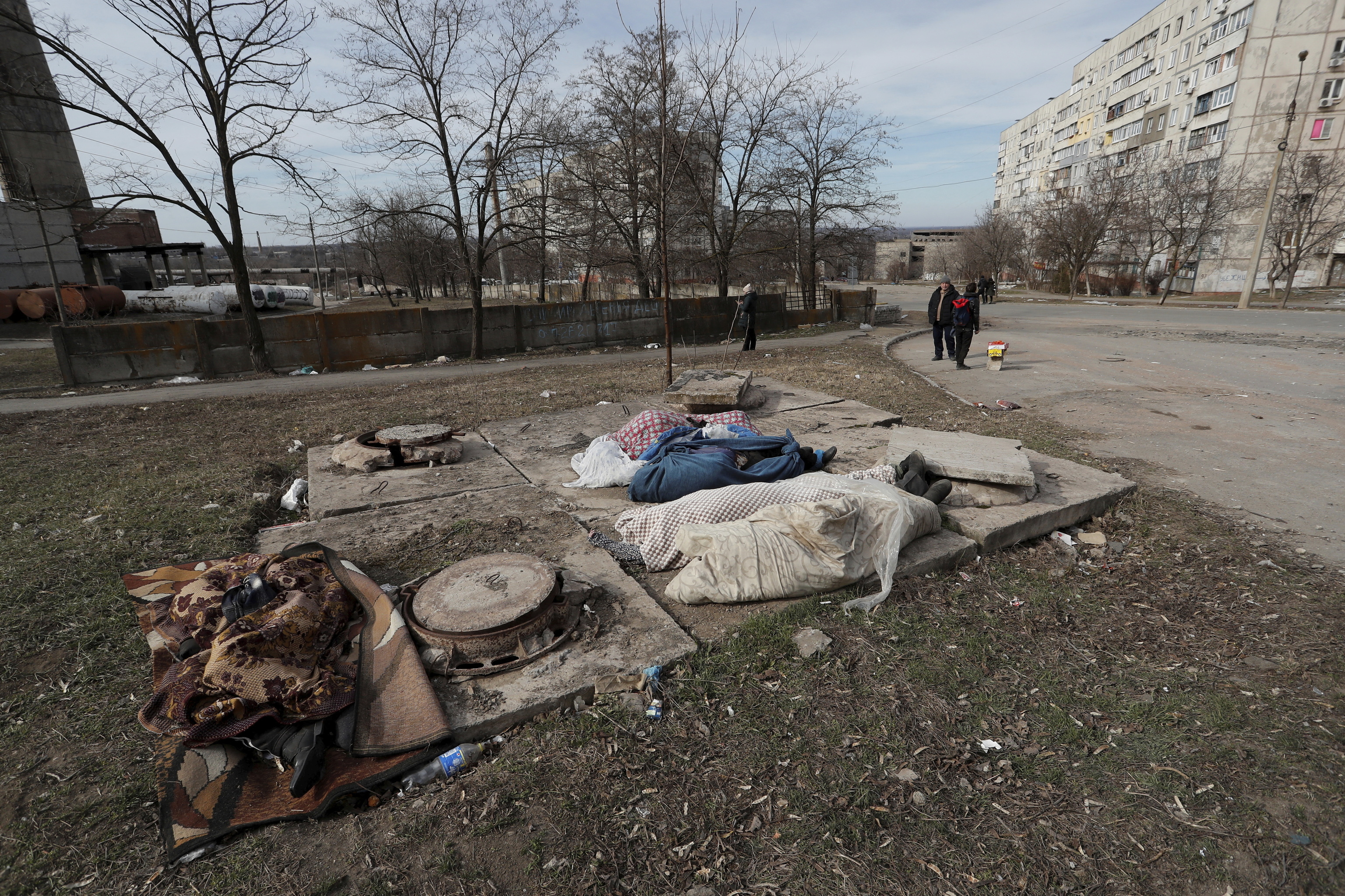 Varios cadáveres tapados con mantas en Mariupol.
