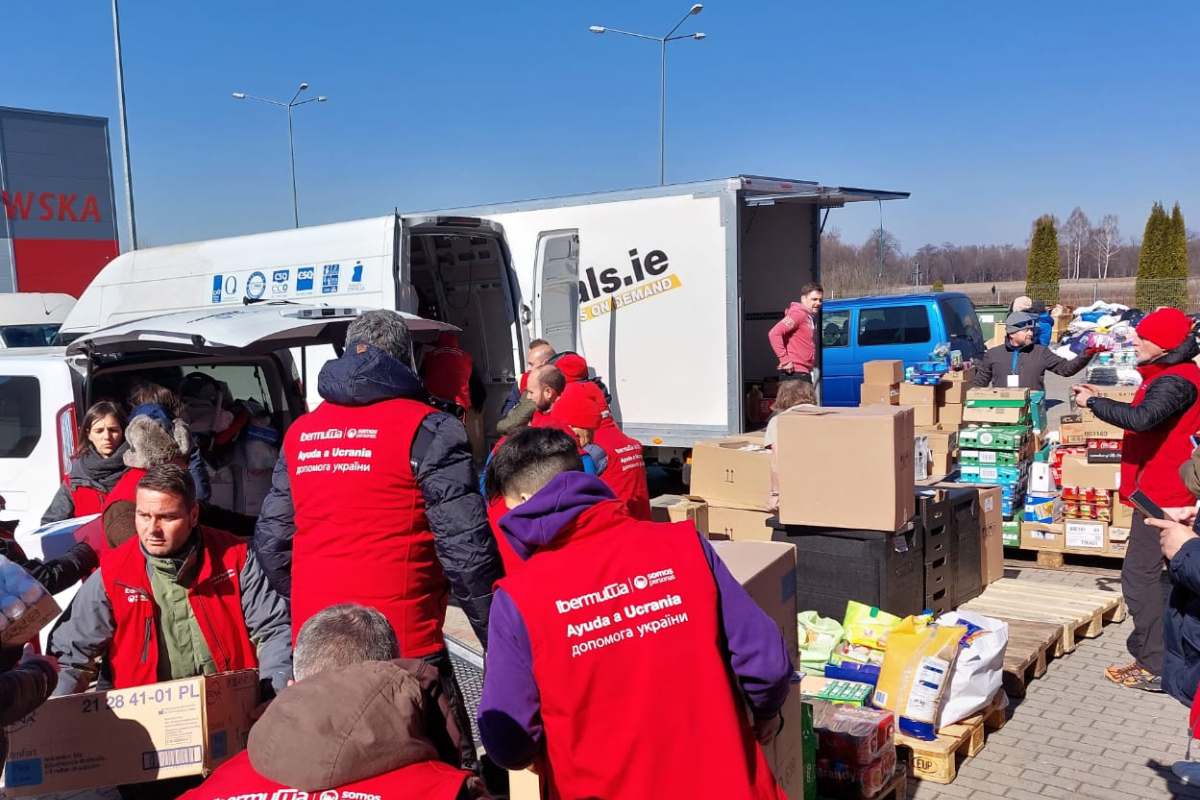 Los miembros de la caravana cargan ayuda para los refugiados