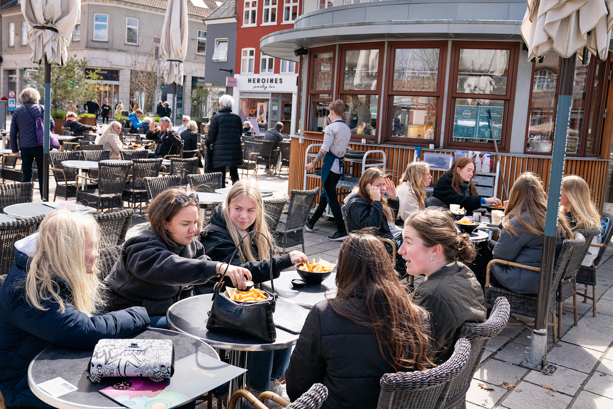 La gente disfruta de los servicios al aire libre mientras los cafés y bares en Roskilde.