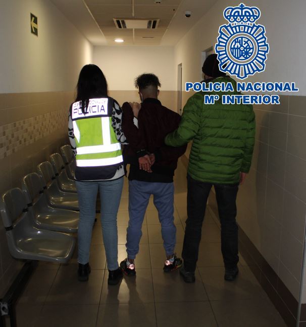 Dos policas nacionales conducen al joven detenido.