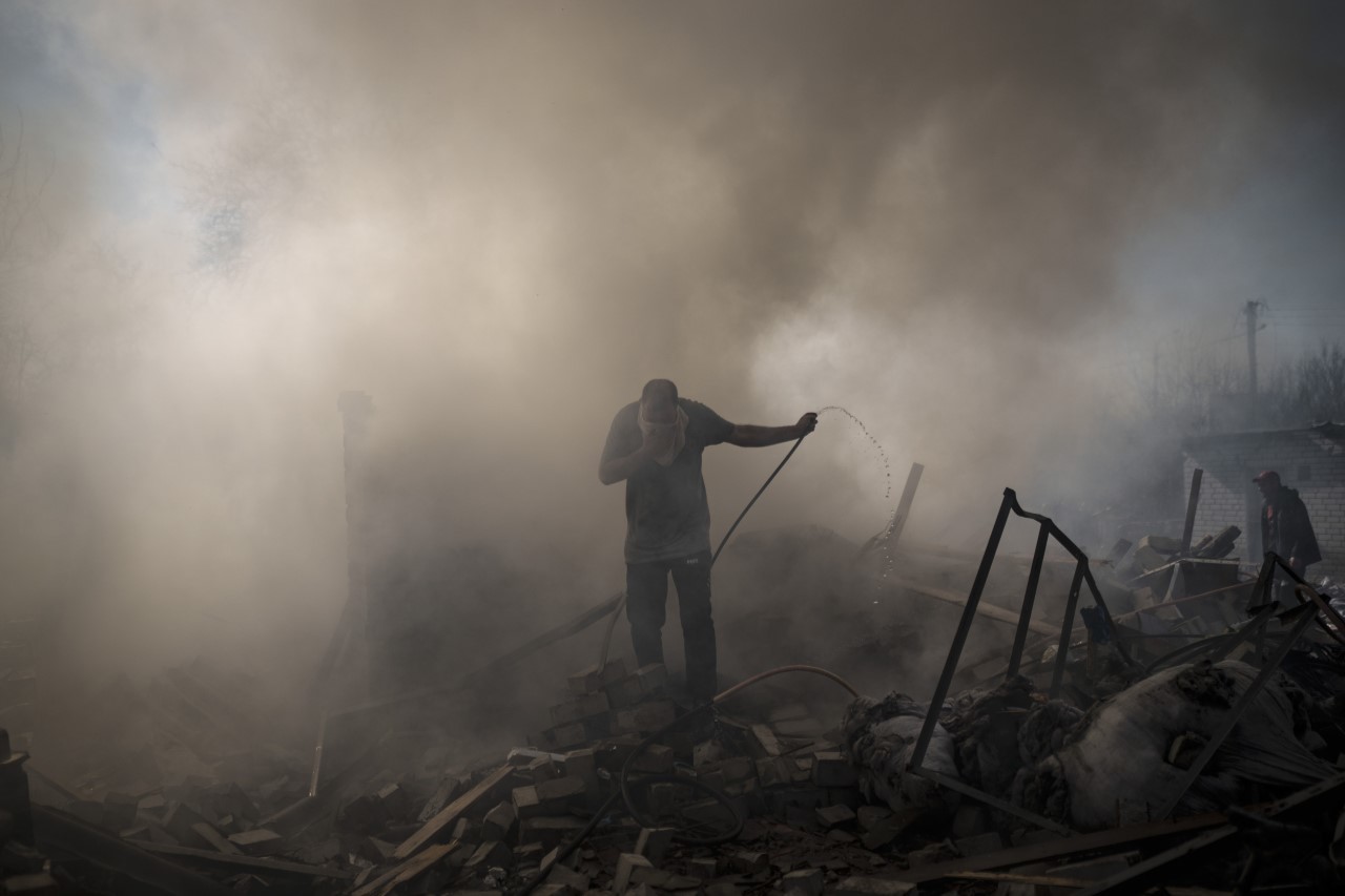 Un hombre intenta apagar el incendio de una casa tras un ataque ruso en Kharkiv, Ucrania